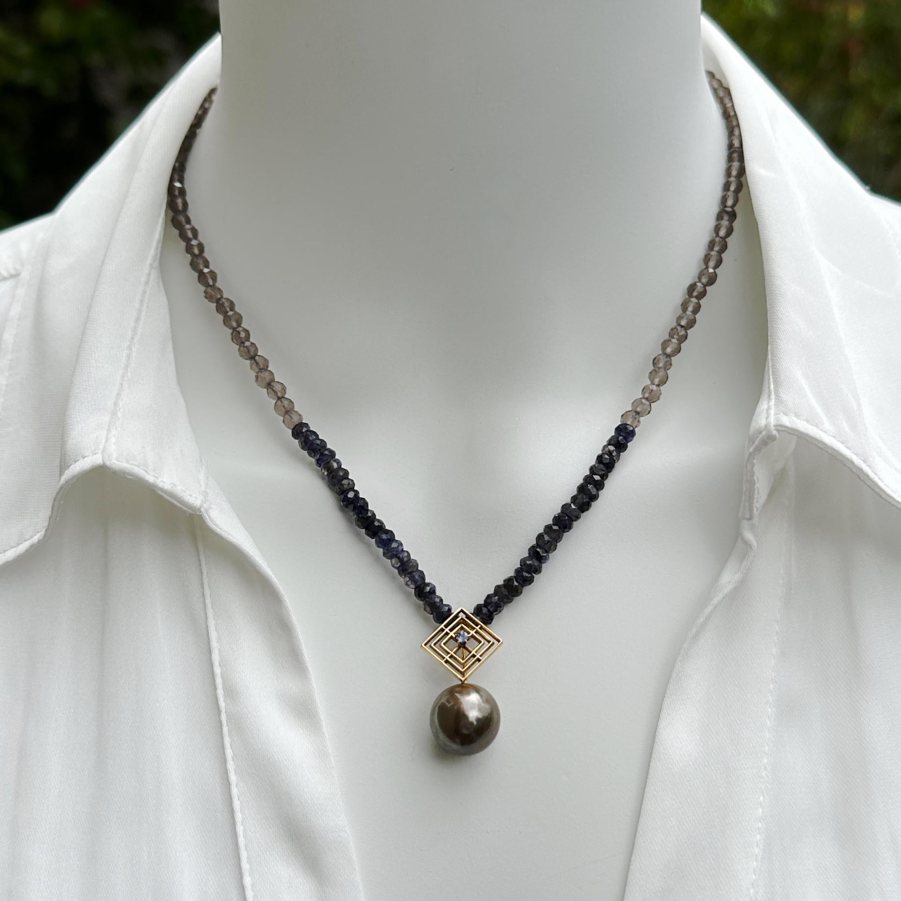 This one-of-a-kind necklace features a near-round 13mm Tahitian pearl in an unusual brown shade.  Topping it off is a vintage 14 karat gold stickpin set with a light blue sapphire.  The chain continues the brown and blue color scheme with dark blue