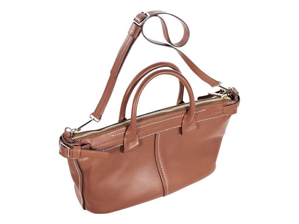 Product details:  Brown leather satchel by Theory.  Accented with white topstitching.  Dual carry handles.  Detachable, adjustable shoulder strap.  Top zip closure.  Leather interior with inner zip pocket.  Goldtone hardware.  18