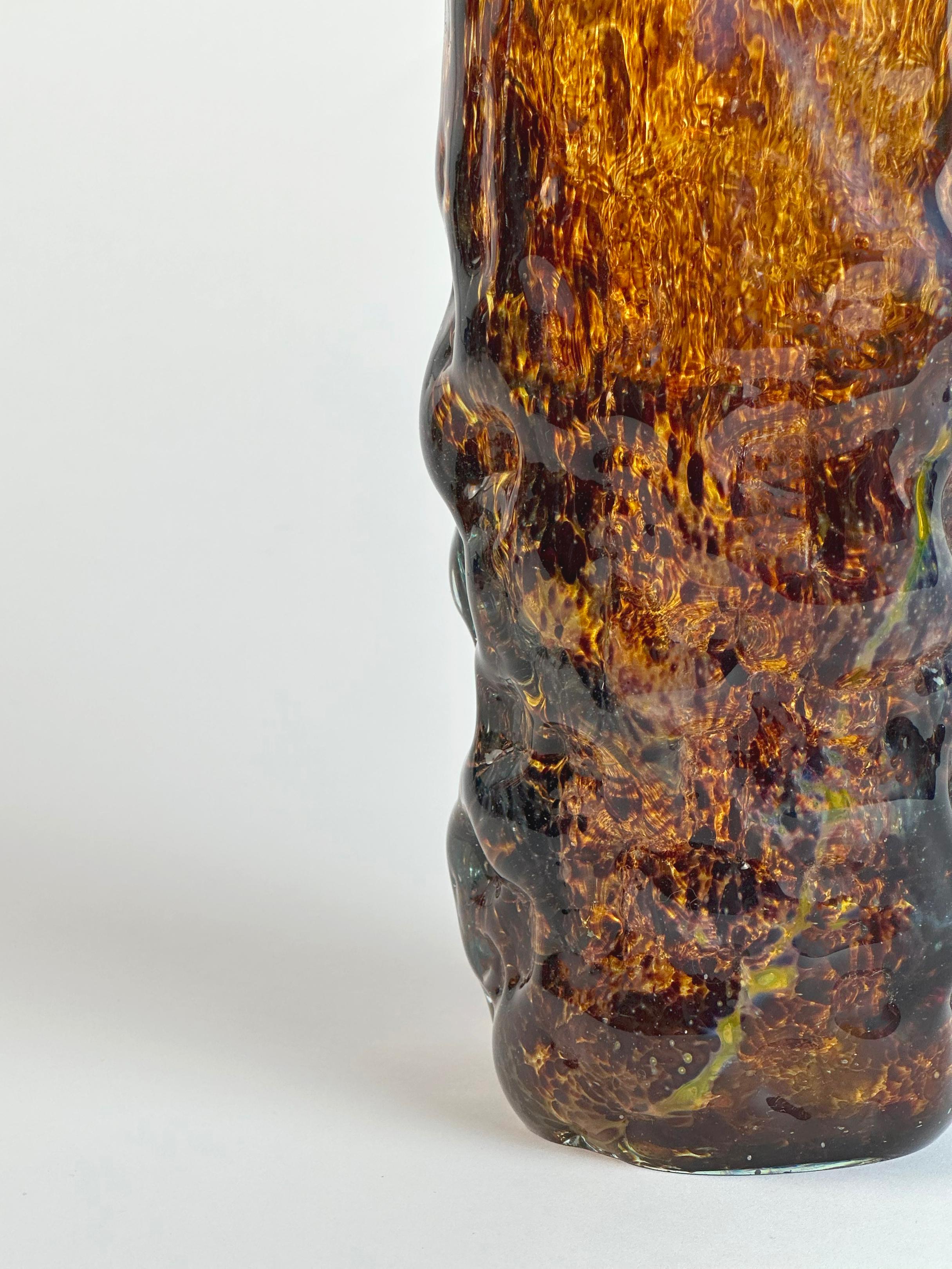Vase en verre d'art richement texturé de Mdina, fabriqué à la main à Malte dans les années 1970. 

Le traitement de surface évoque l'effet classique de l'écaille de tortue, avec des champs marbrés d'un brun profond superposés à un verre translucide