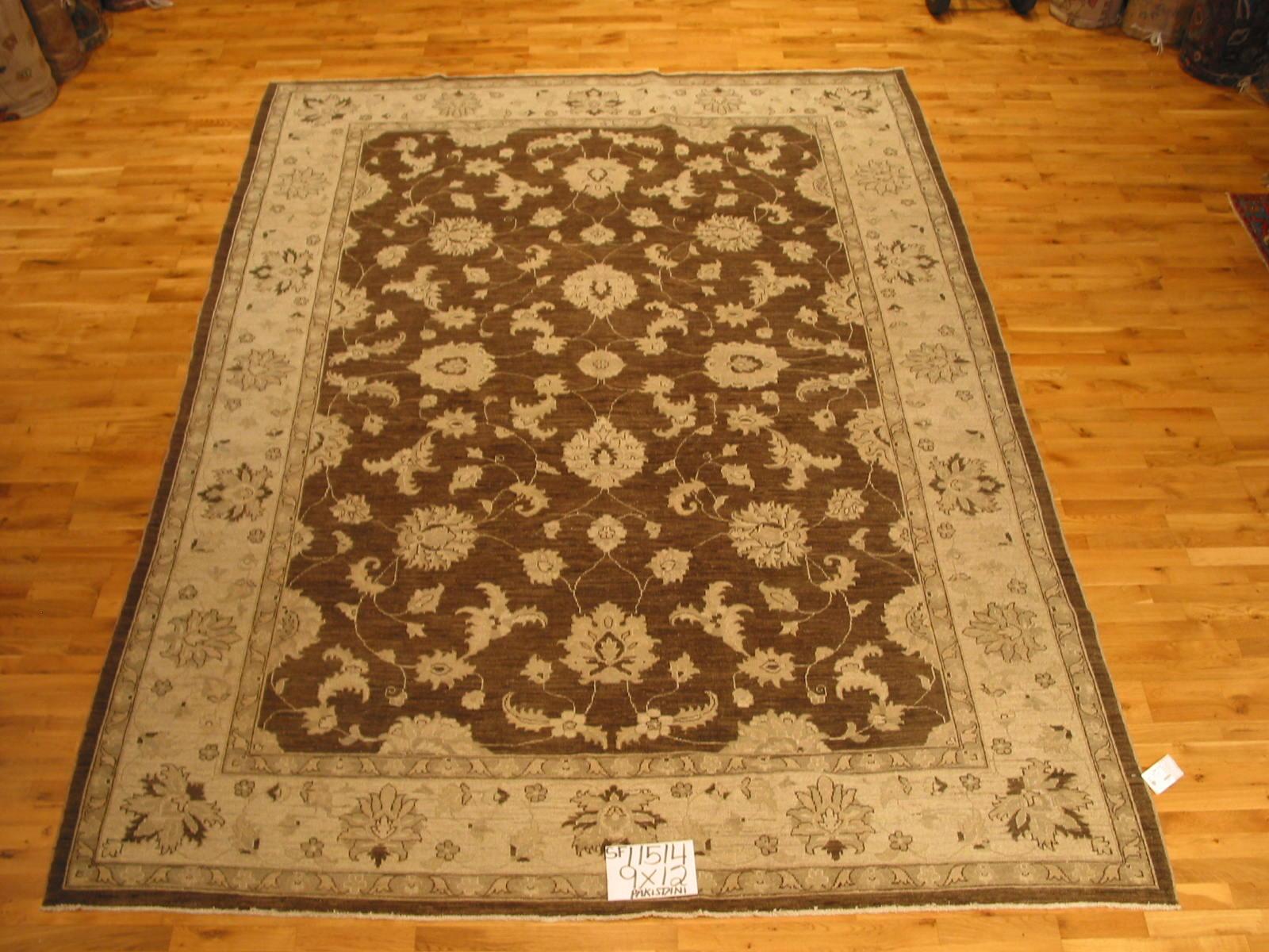 A deep brown center panel with swirling floral motif framed by a wide beige floral border. Durable hand knotted wool construction creates a rug that will last for years to come in the home or office. Made in Pakistan using vegetal dyes.