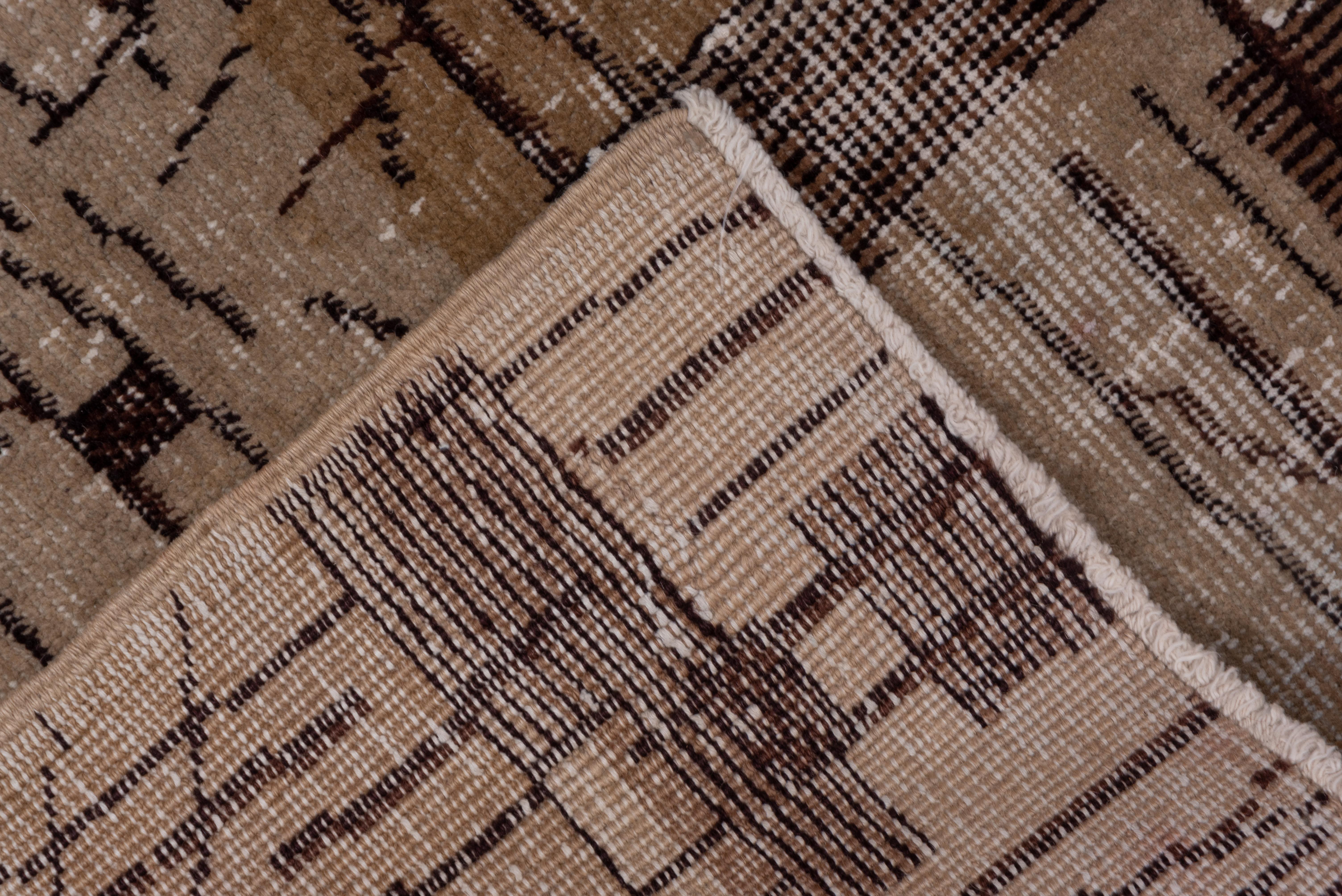 This lightly distressed, borderless Turkish totally geometric scatter shows a vertical dash and broken line pattern overlaying color blocks in browns, beige and straw. The pattern is laid out on a three by five plus gridwork.
 
