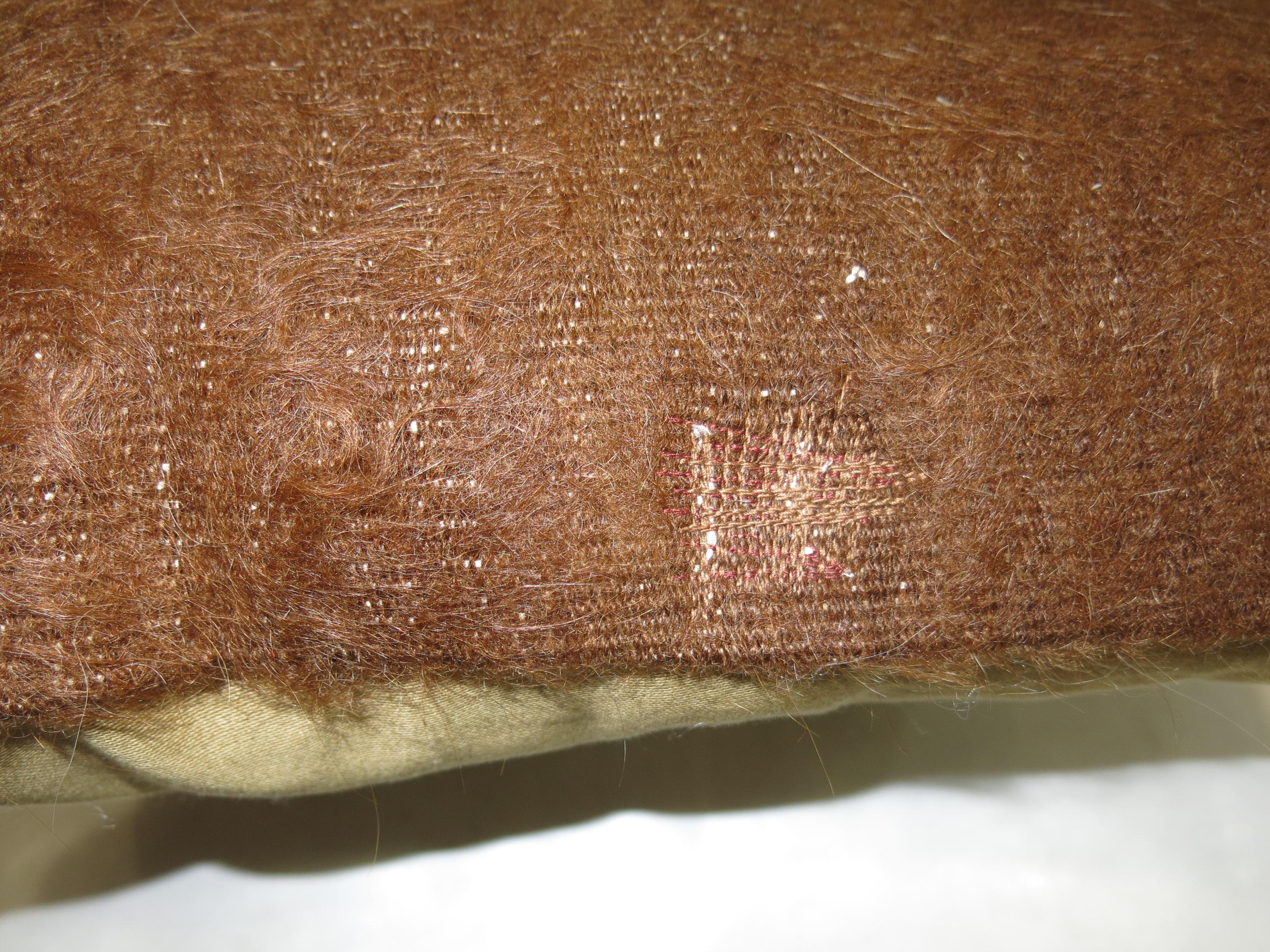 Ein Kissen aus einem braunen türkischen Mohairteppich.