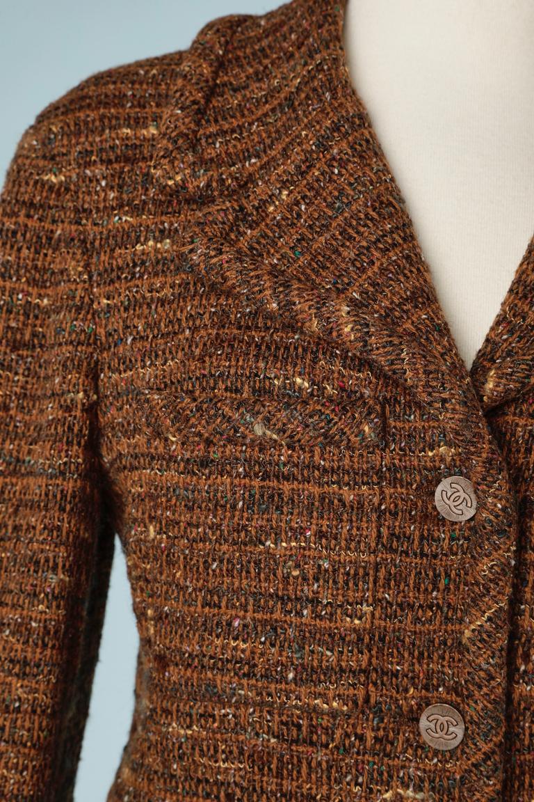 Brown tweed skirt-suit with branded silk lining. Small shoulder pads. Chain inside the jacket in the bottom. Branded buttons. 
Fabric composition: 80% wool, 20% acrylic
SIZE 42 on tag but more likely 38 (M) 