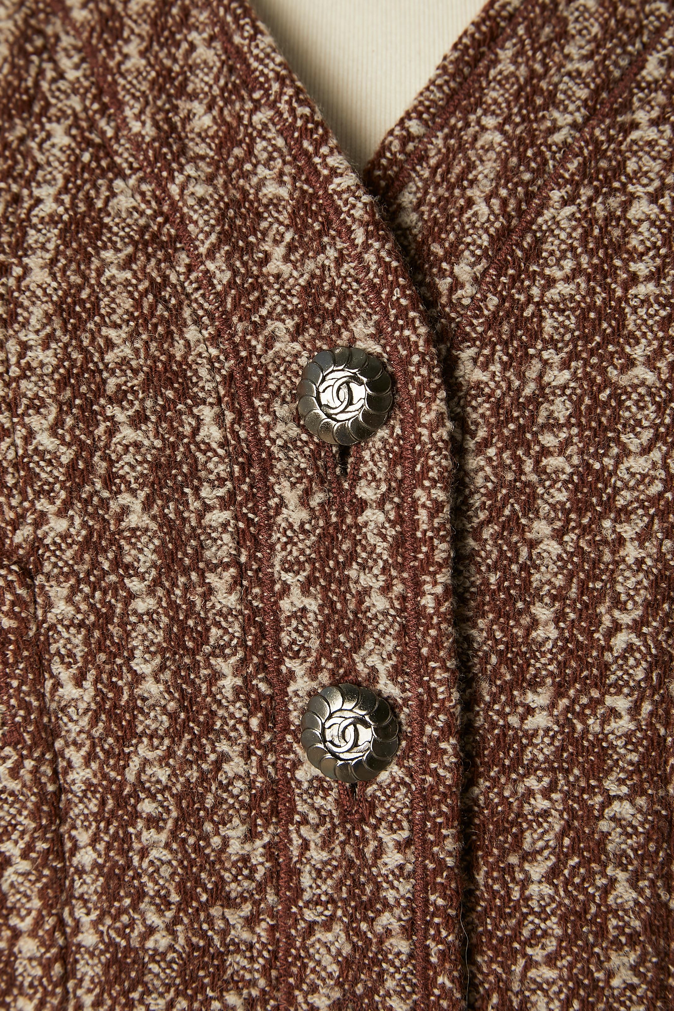 Combinaison en tweed marron avec jupe plissée. Composition du tissu : 90% laine, 10% nylon. Doublure : 95% soie, 5% lycra. Doublure marquée 