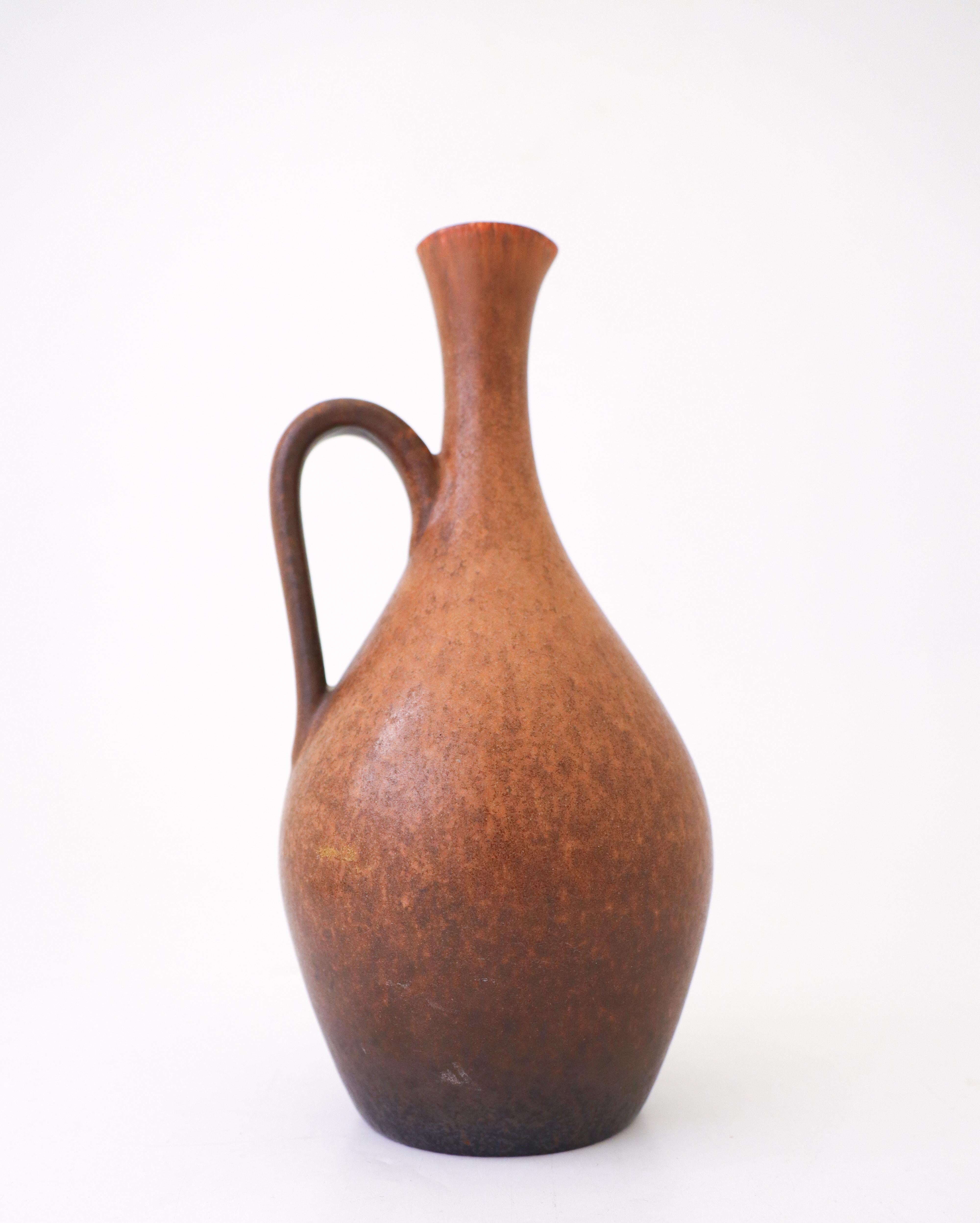 A ceramic vase with a brown glaze designed by Carl-Harry Stålhane at Rörstrand. The vase is 24 cm (9.6