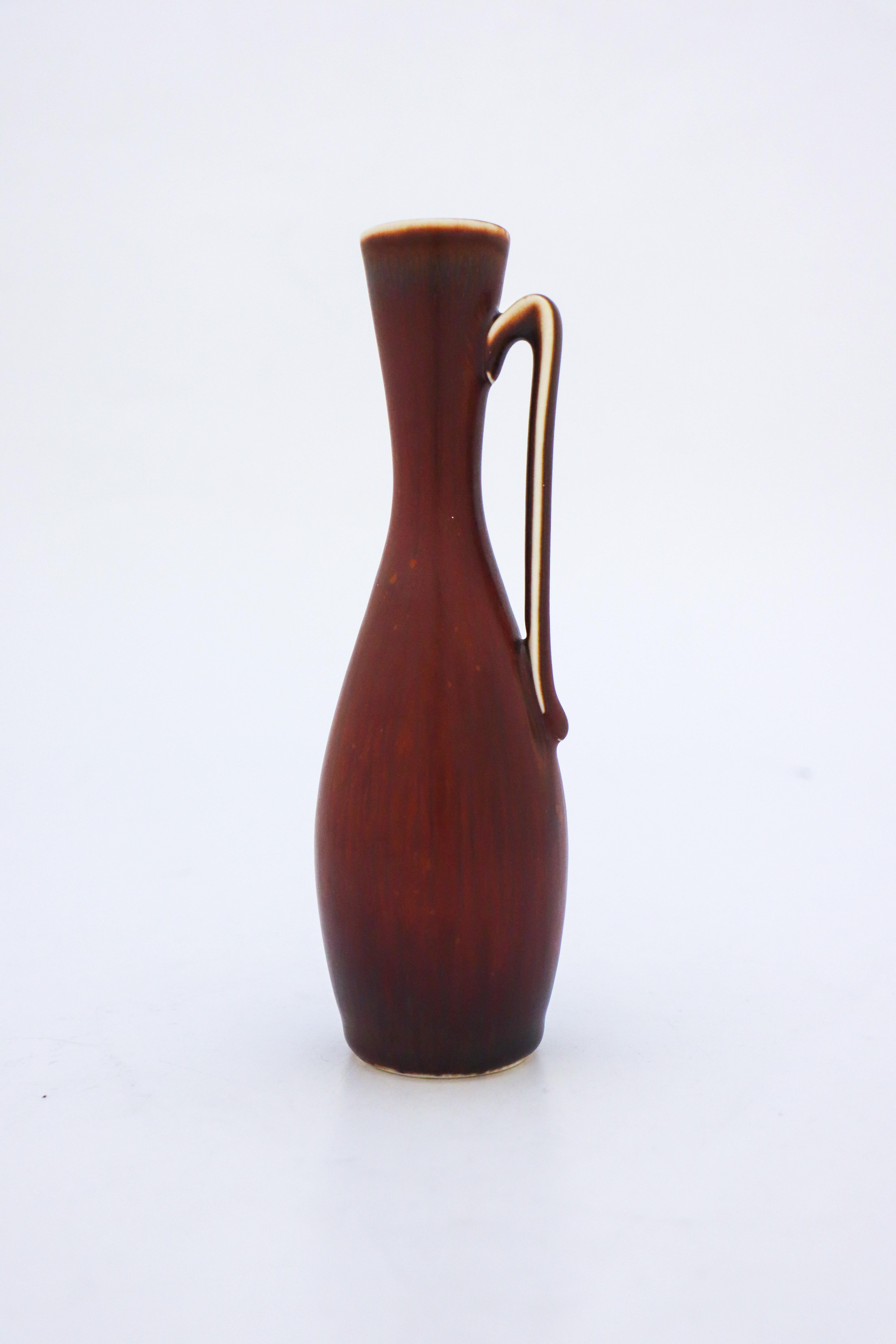 A brown vase designed by Gunnar Nylund at Rörstrand, it´s 17.5 cm (7) high. It´s in mint condition and marked as 1:st quality. 

Gunnar Nylund was born in Paris 1904 with parents who worked as sculptors and designer so he really soon started hos