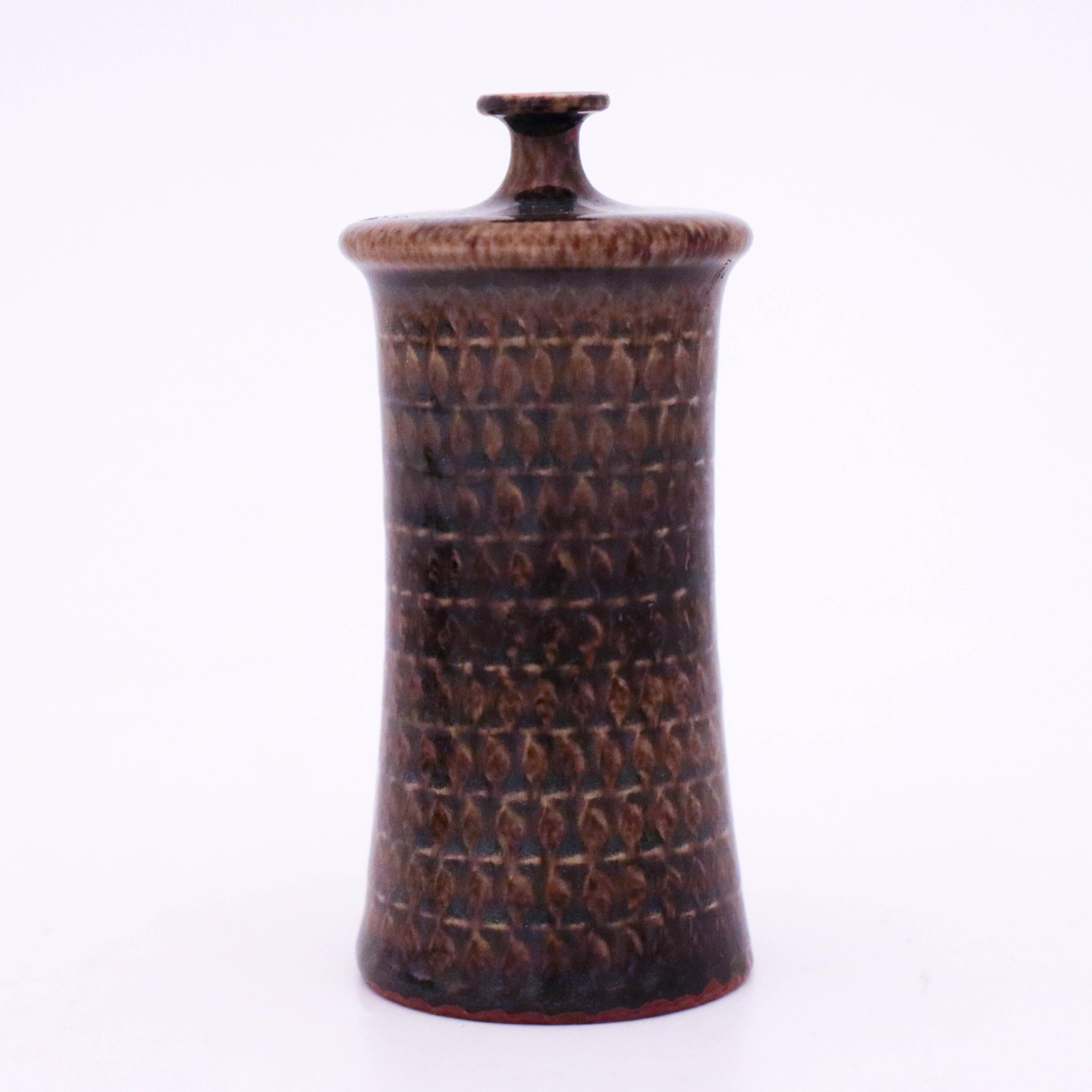 A brown vase designed by Stig Lindberg at Gustavsberg. It is 11 cm high and 5 cm in diameter and in very good condition. The vase is designed in the 1950s.