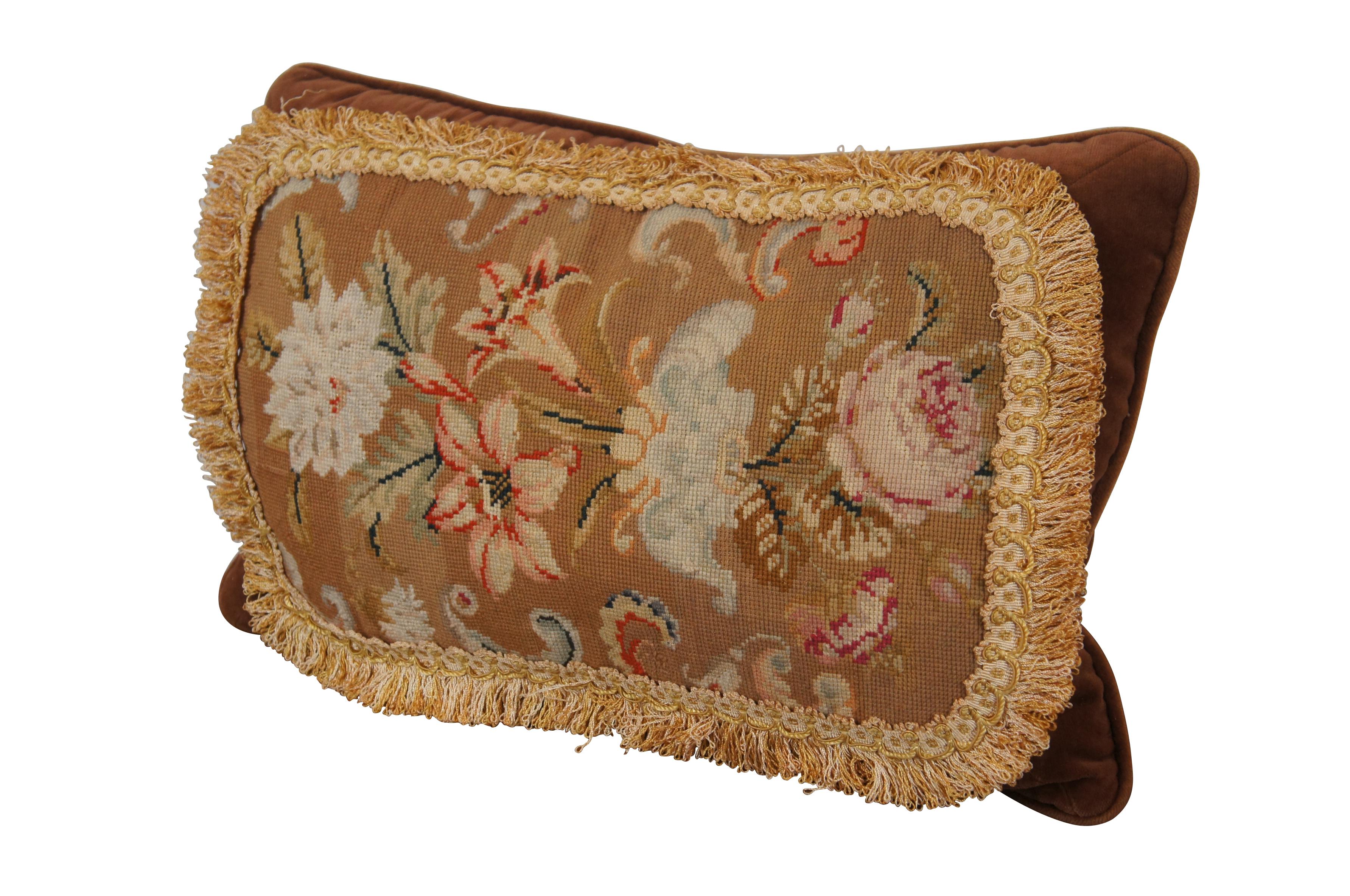 20th century down filled brown velour / velvet lumbar throw pillow, hand embroidered with an array of flowers, roses and lilies on a camel brown background, framed in cream and gold fringe. Brown velvet / velour back with piping along seams. Sewn