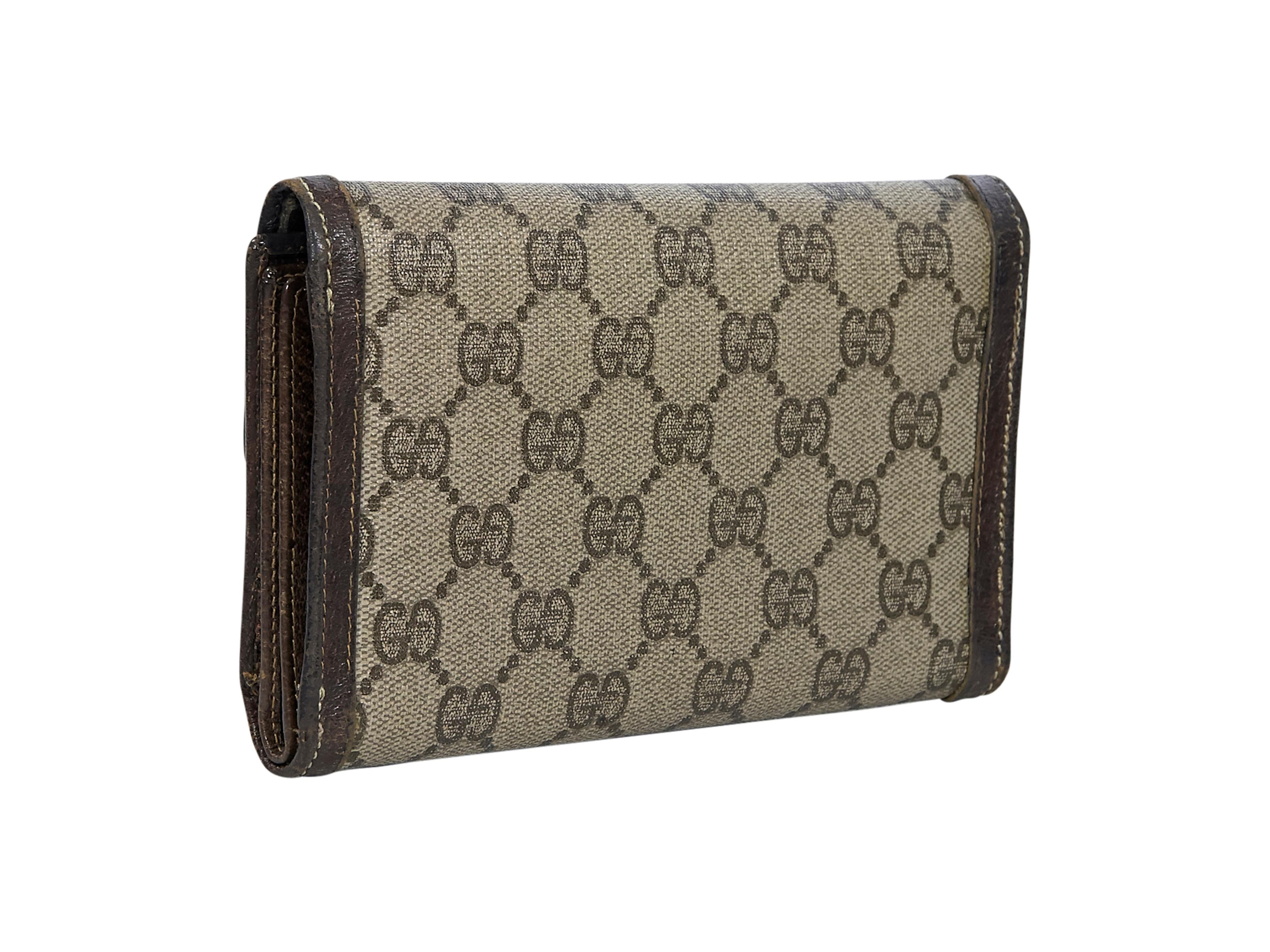 Product details:  Vintage brown canvas printed trifold wallet by Gucci.  Leather-trimmed. GG diamanté logo-patterned. Snap closure.  Lined interior with multiple credit card slots and ID slot. 6.75