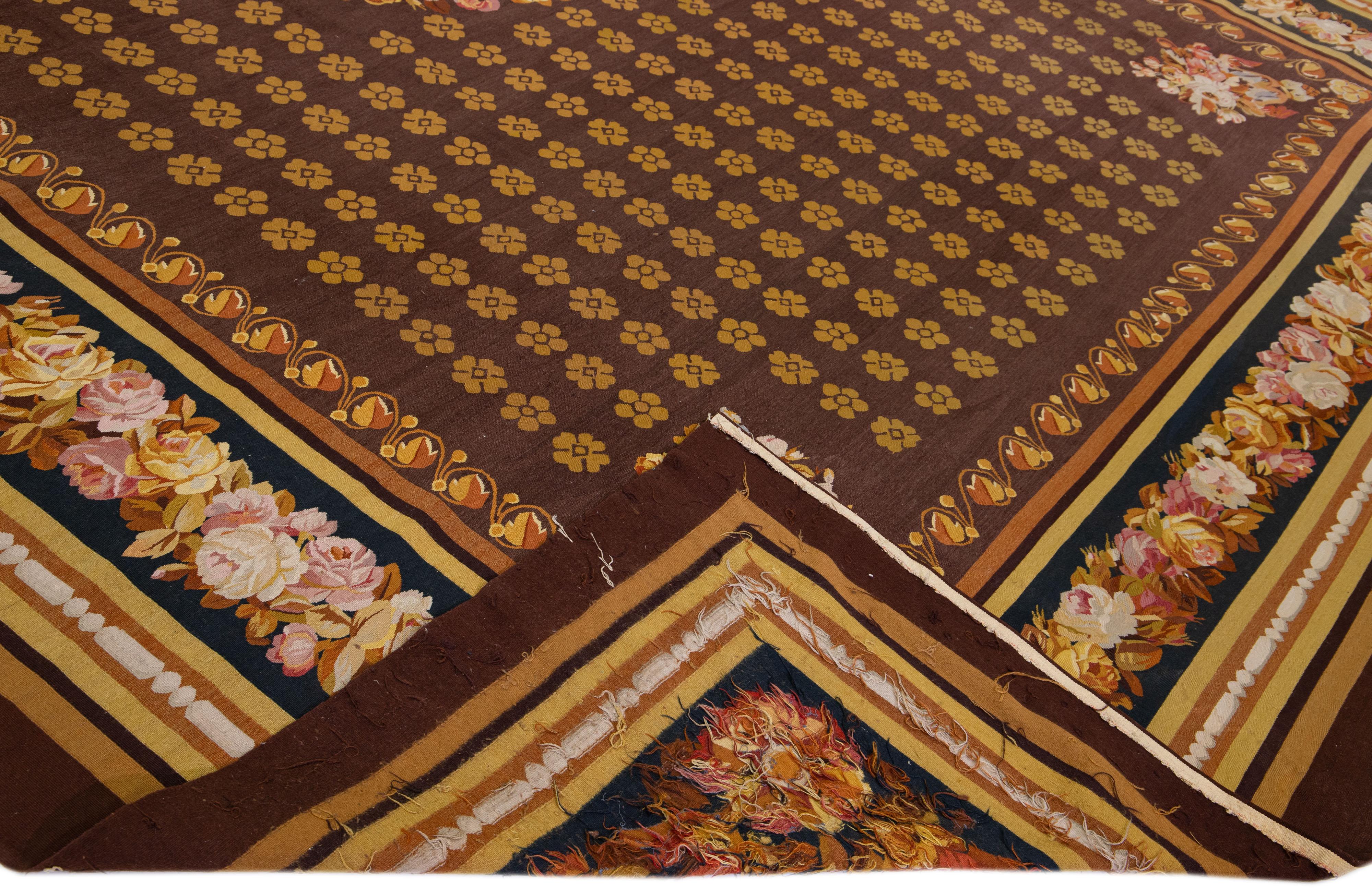 Beautiful Vintage Aubusson needlepoint wool rug with a brown color field. This piece has fine details with an elegant floral pattern throughout the design.

This rug measures 14'8