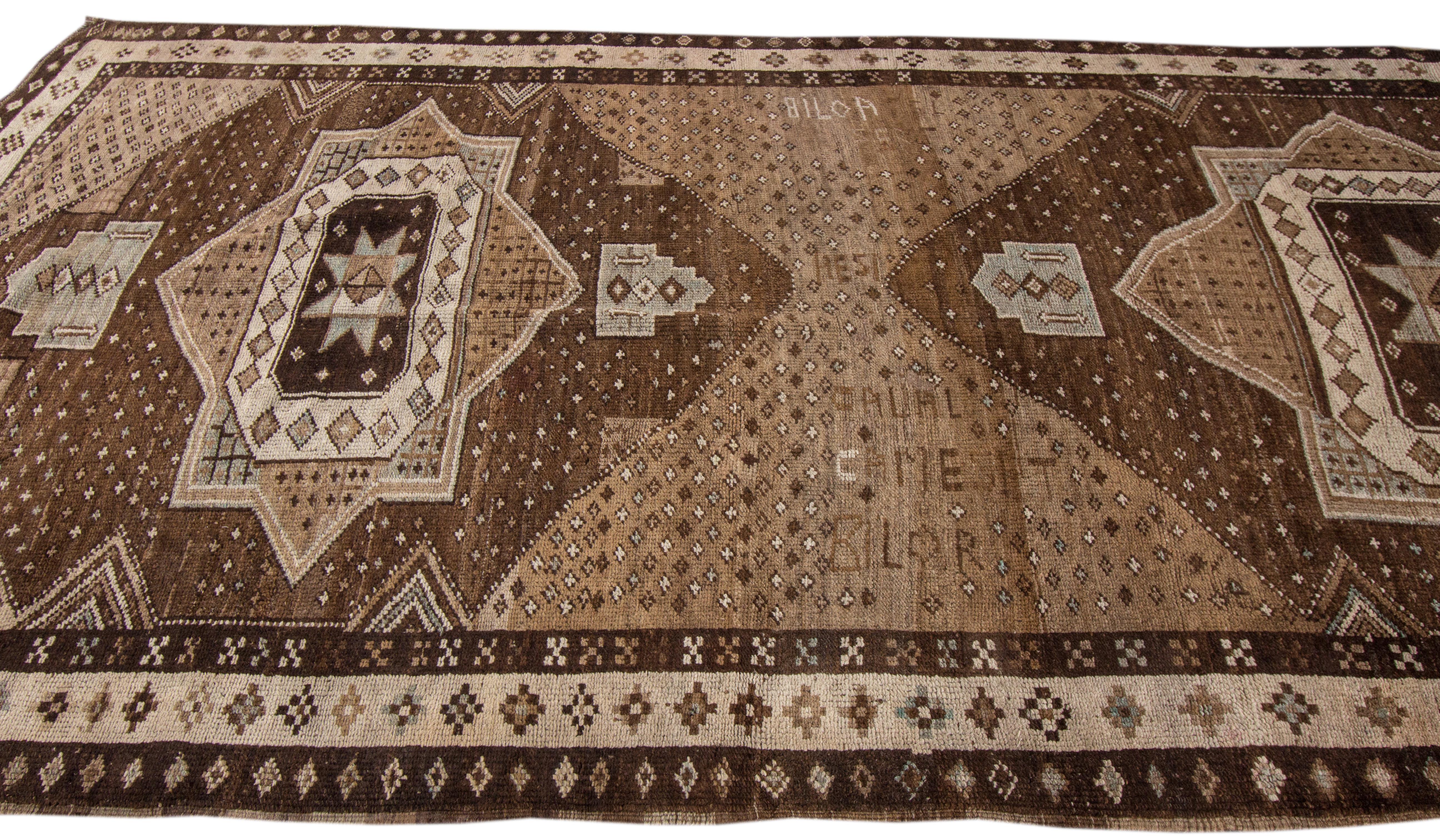 Beautiful vintage Anatolian hand-knotted wool rug with a brown color field. This piece has a beige accent in a gorgeous geometric Tribal design.

This rug measures 5'6
