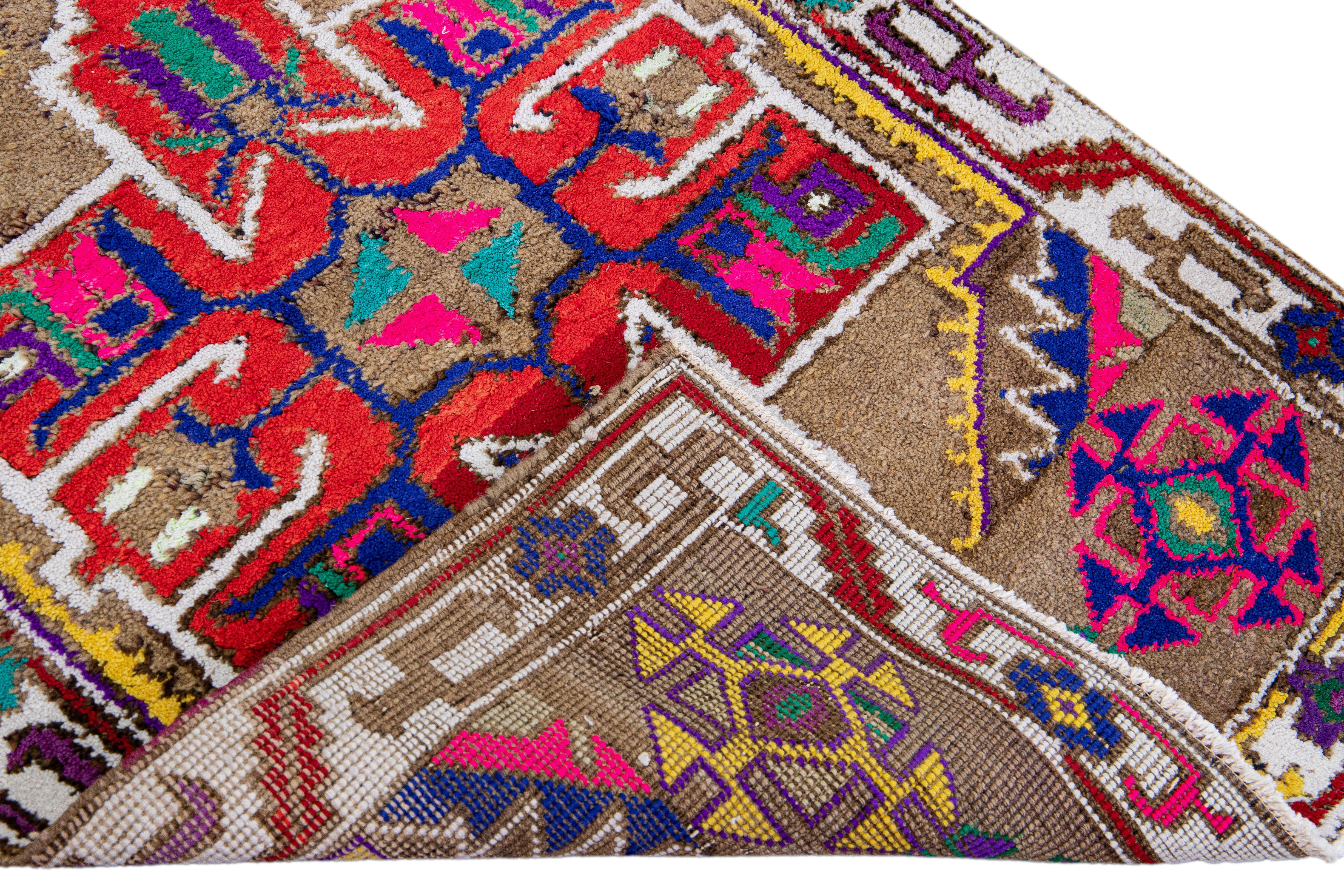 Beautiful vintage Turkish hand-knotted wool rug with a tan field. This rug has a white designed frame and multicolor accents in a gorgeous all-over geometric tribal design.

This rug measures: 3' x 8'11