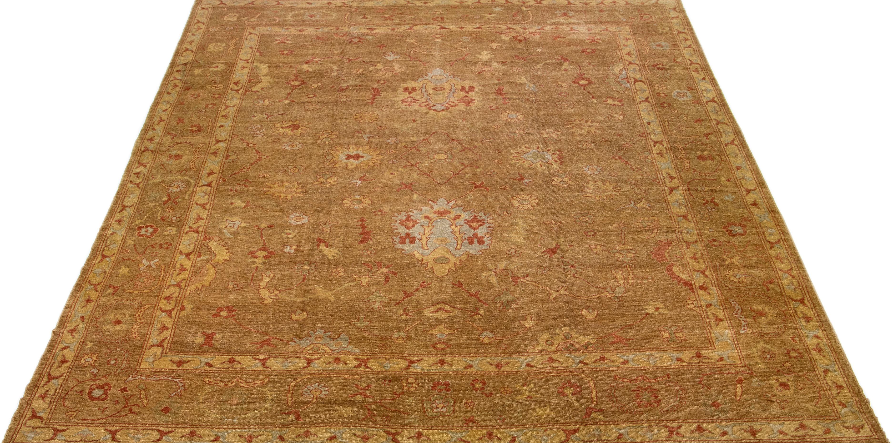 Beautiful Modern Turkish Oushak hand-knotted wool rug with a brown color field. This rug has gray and rust accents in a gorgeous large-scale floral pattern.

This rug measures 14'9