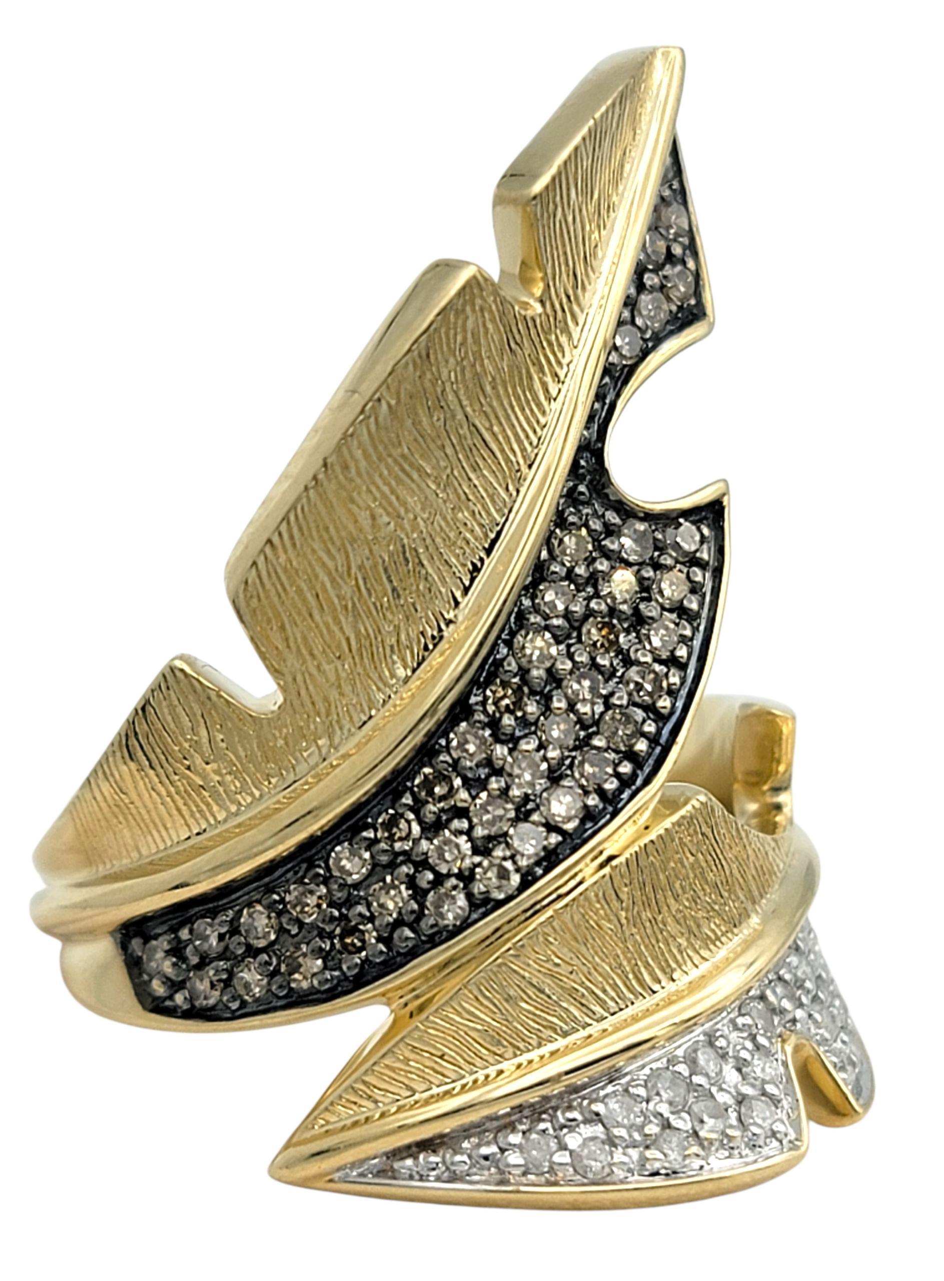 This sculptural diamond ring captures an elegant sense of motion with its fluid, leaf-like design. Crafted in 14 karat yellow gold, the piece gracefully wraps around the finger in an open, asymmetrical form, with each curve shimmering in rows of
