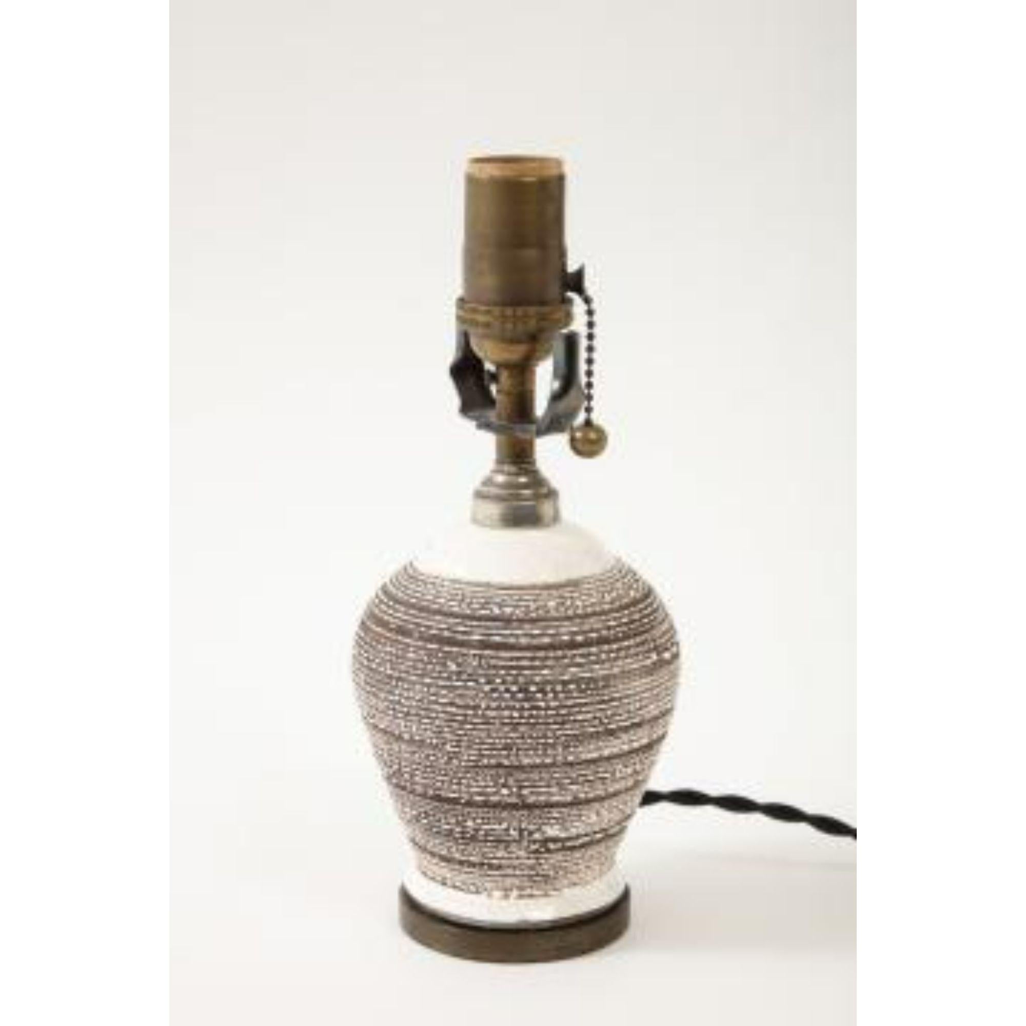Small Brown and White Textured Table Lamp, circa 20th century

This lamp has been newly rewired, mounted onto a custom bronze base, and outfitted with a black twisted silk cord.

