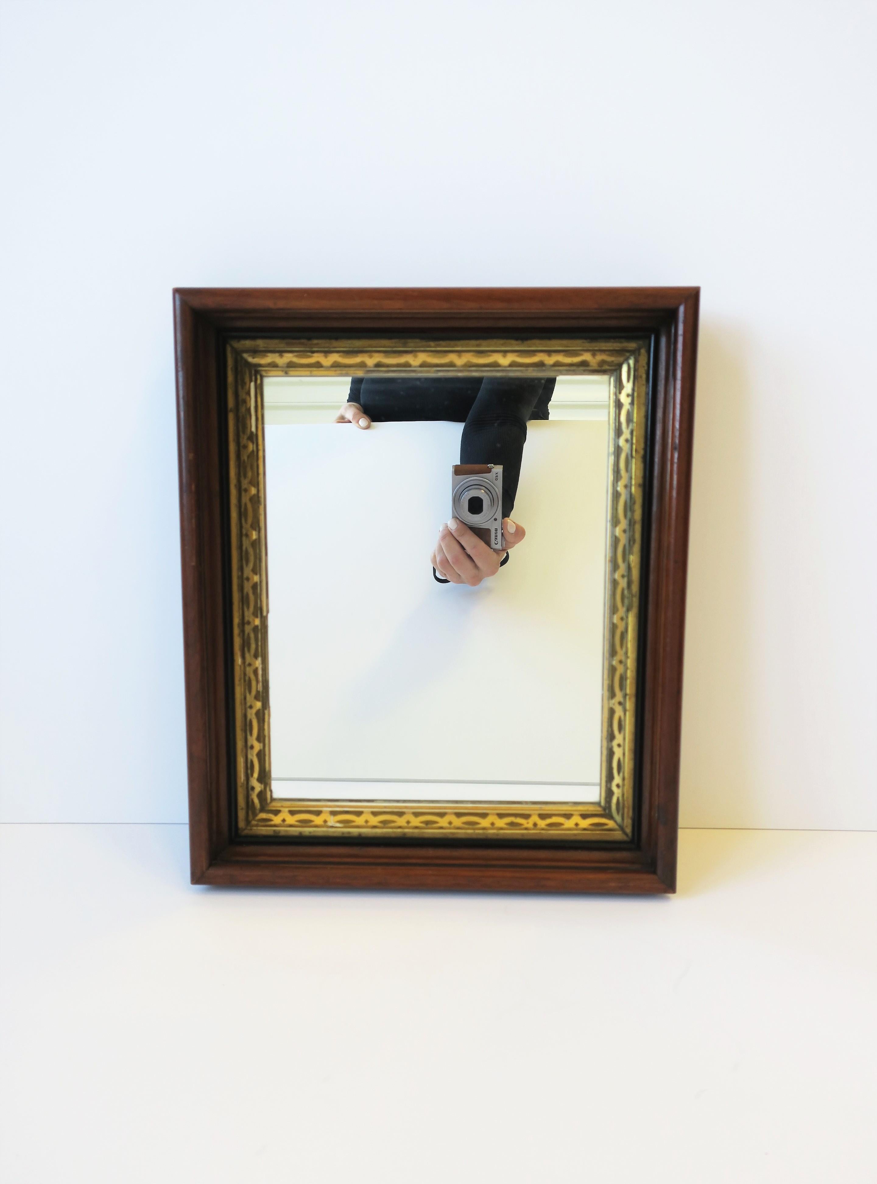 A beautiful wall mirror with a rich brown wood and gold giltwood frame, circa early to mid-20th century. Handmade frame is brown, black and gold, and ready to hang as shown in last image. A great piece for a hall wall, vanity, bathroom, or