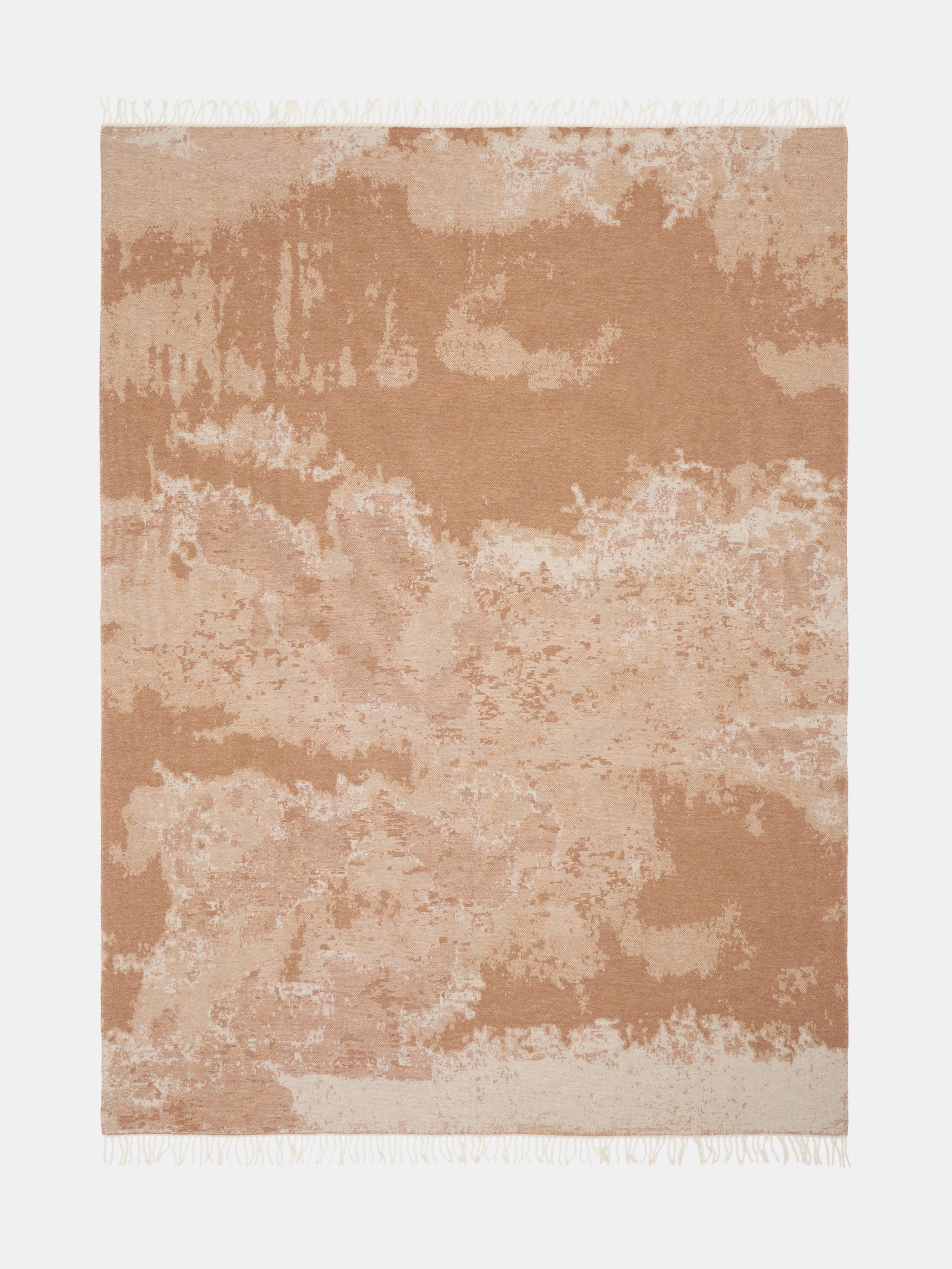 Elegante manta confeccionada en Como (Italia) con una lujosa mezcla de 85% de lana y 15% de cachemira. El estampado jacquard efecto mármol en cálidos tonos arena y marfil añade sofisticación natural a cualquier interior. Suave, acogedora y