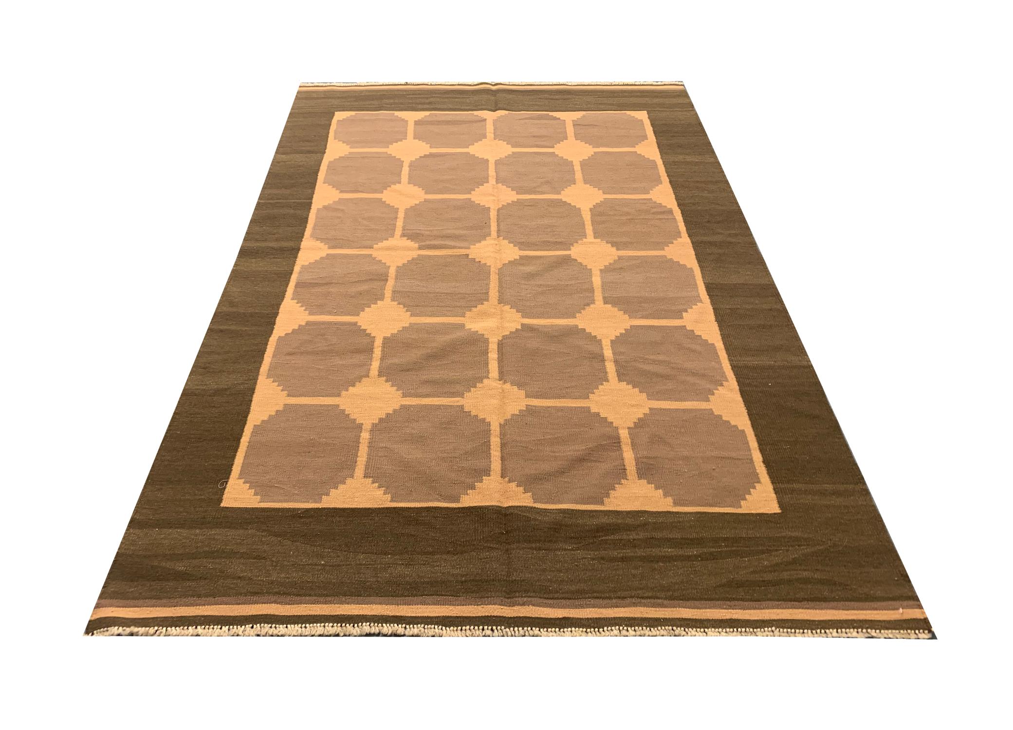 This elegant wool area rug was woven by hand in the 1960s in the Caucasus area. The design features a bold art deco style with a repeat geometric pattern—Woven with a subtle colour palette including orange, brown and beige. The colour and design of