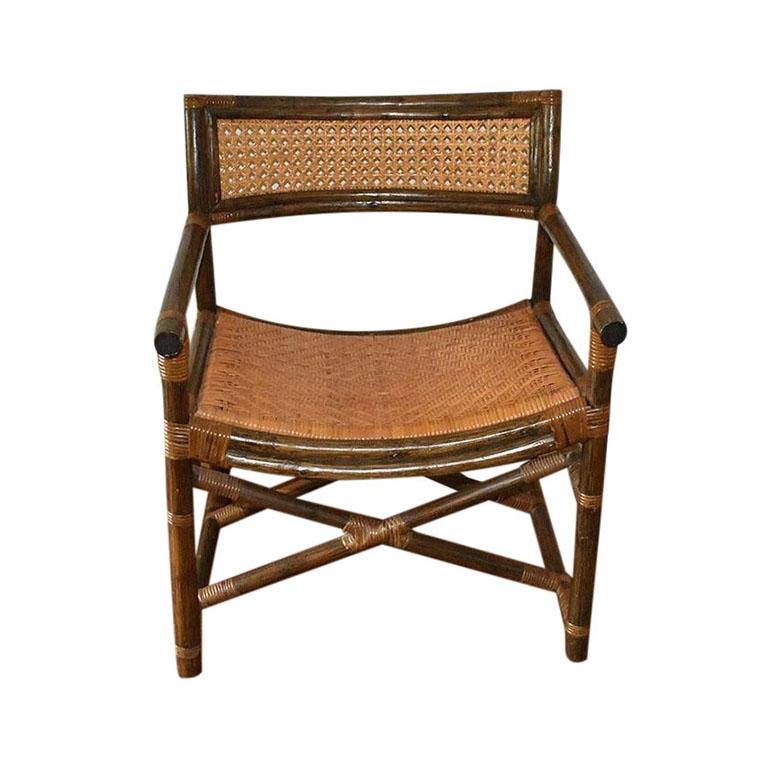 A mid-century safari chair with a cane back, and woven fiber seat. This fabulous armchair features double stretchers at the bottom for extra stability. The seat is woven of natural fibers in a basketweave pattern. The back has a cane accent and is