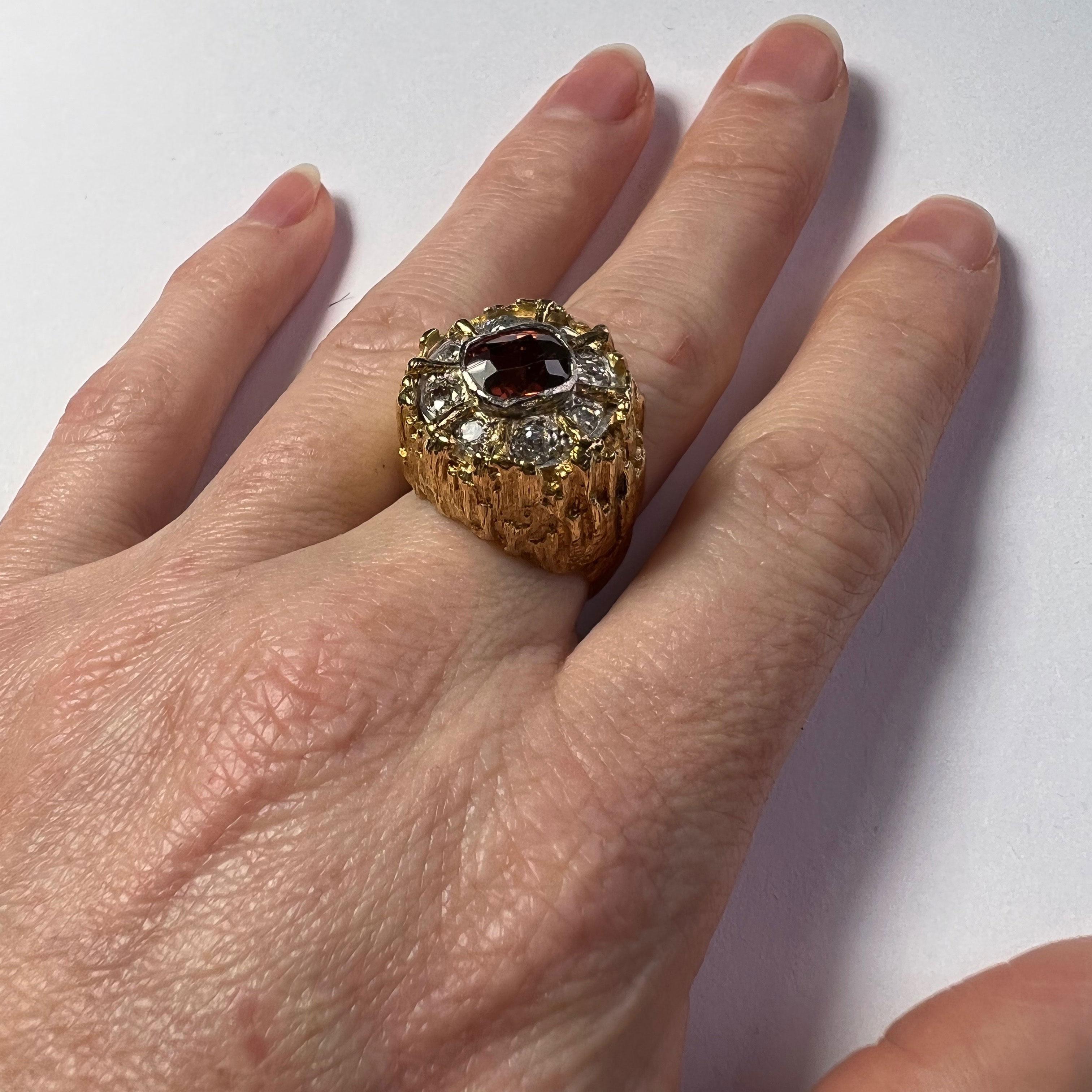 An organic textured 18 karat gold ring set with a cushion cut brown zircon weighing approximately 2.55 carats surrounded by eight single cut and old cut diamonds.

The ring is marked for 18 karat gold and date marked for London, 1974. Makers mark