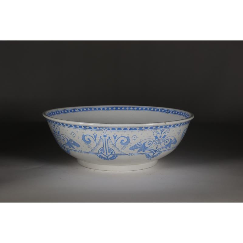 Brownfield and Sons Olympus pattern, in the style of Dr C Dresser. A large Aesthetic Movement white bowl with blue printed love birds and stylized decoration around the bowl.
