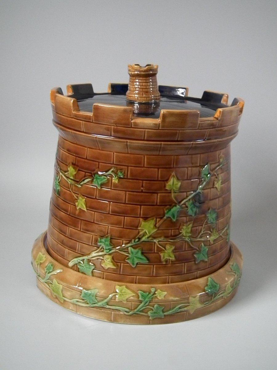 Brownfield Majolica cheese keep which features a castle tower with ivy trailing up the sides. Colouration: brown, cobalt blue, green, are predominant. The piece bears maker's marks for the Brownfield pottery. Bears a pattern number, '2009 12/46'.
