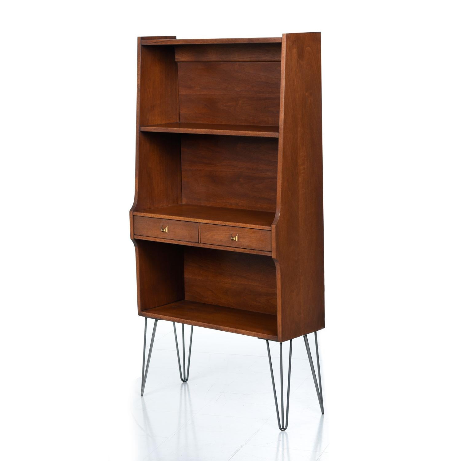 These three Broyhill Brasilia bookcases have been updated with stylish, heavy duty and period appropriate hairpin legs. The walnut wood veneer exhibits fiery grain walnut. The deep chocolate brown patina comes from decades of aging with loving care.