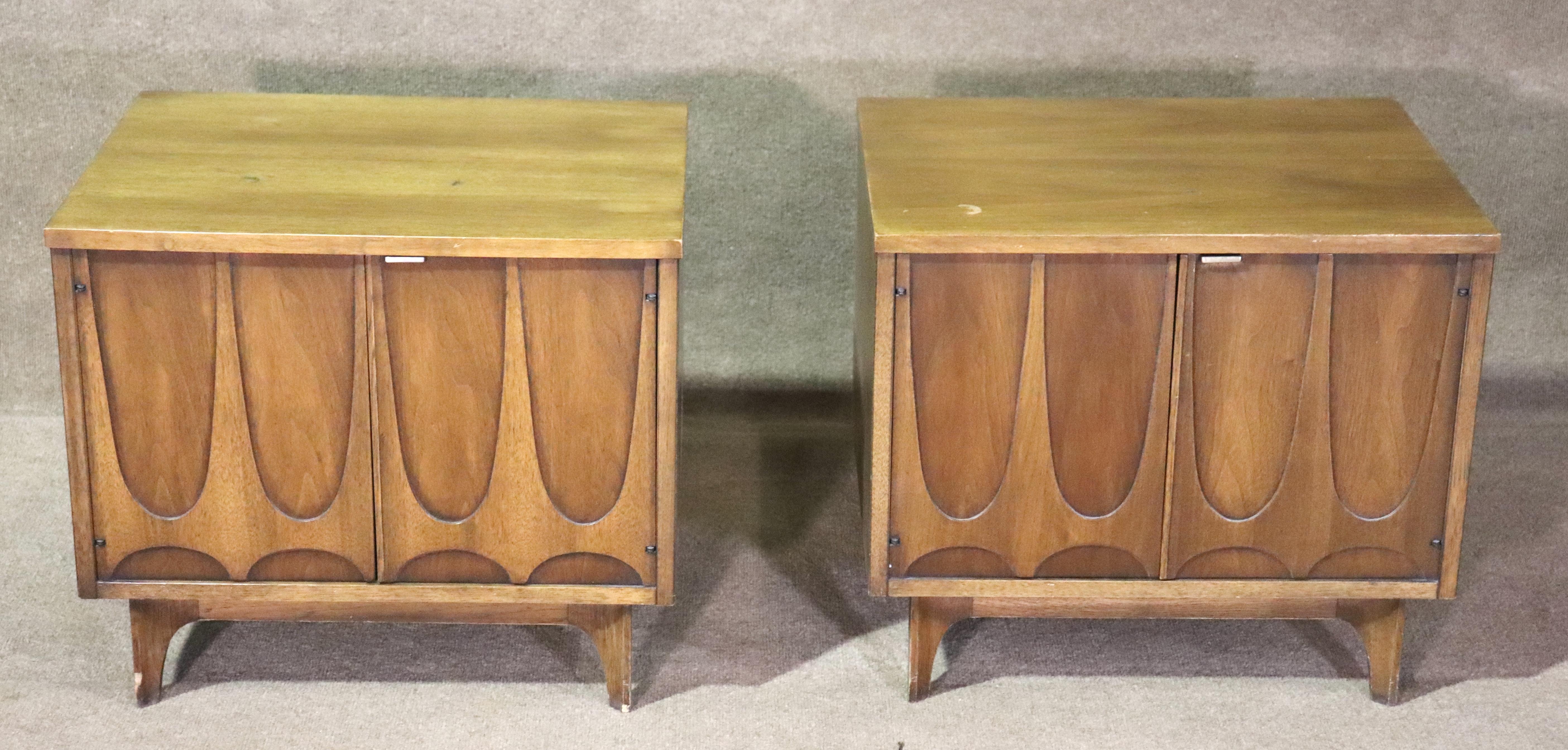 Pair of mid-century modern iconic end table cabinet by Broyhill for their 'Brasilia' line. Featuring the unmistakable sculpted arches on each door, walnut grain throughout, and tapered legs. These standout beside your sofa or bed.
Please confirm