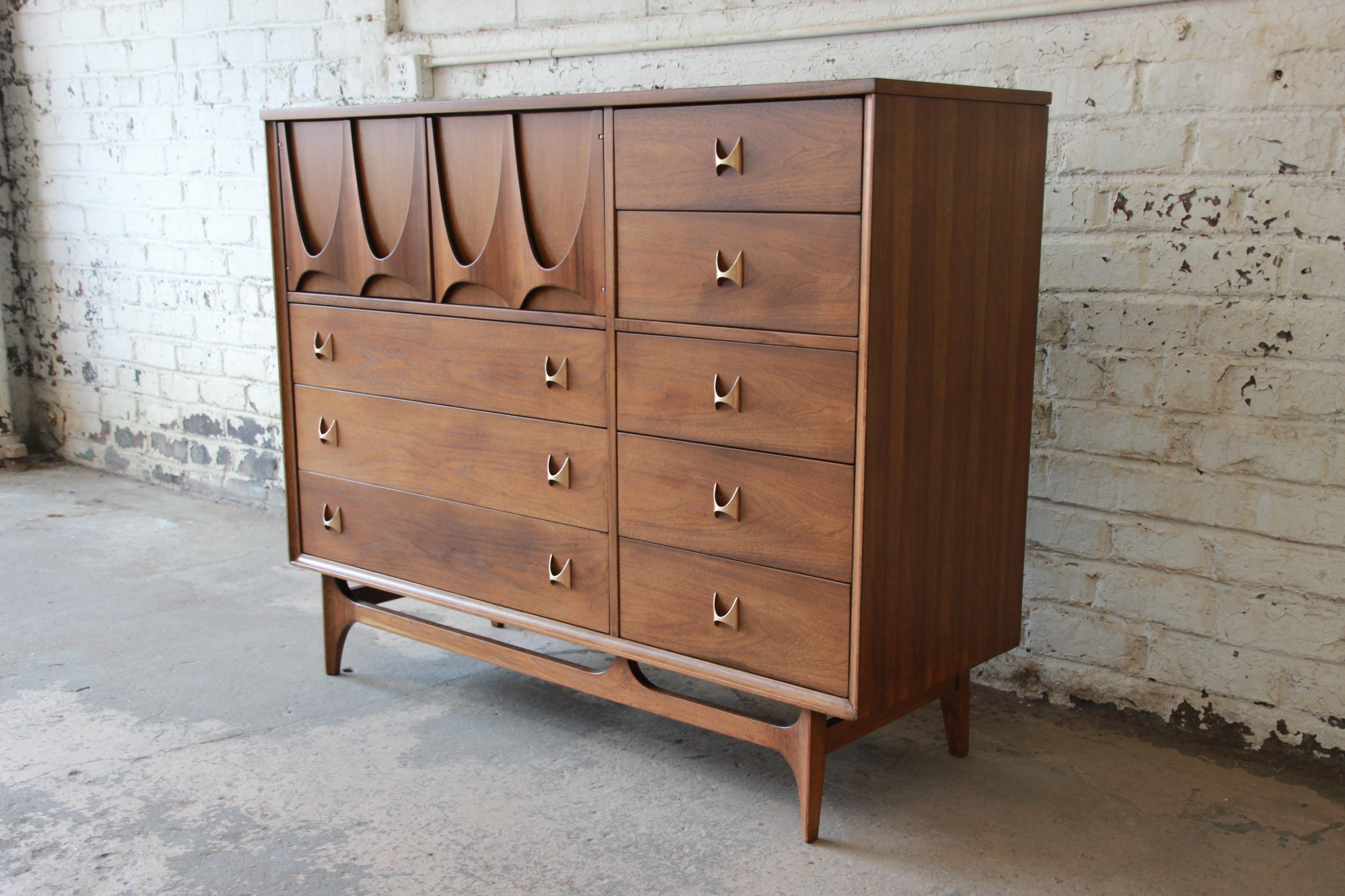 An outstanding Mid-Century Modern sculpted walnut highboy dresser or chest of drawers by Broyhill Brasilia. This is the 