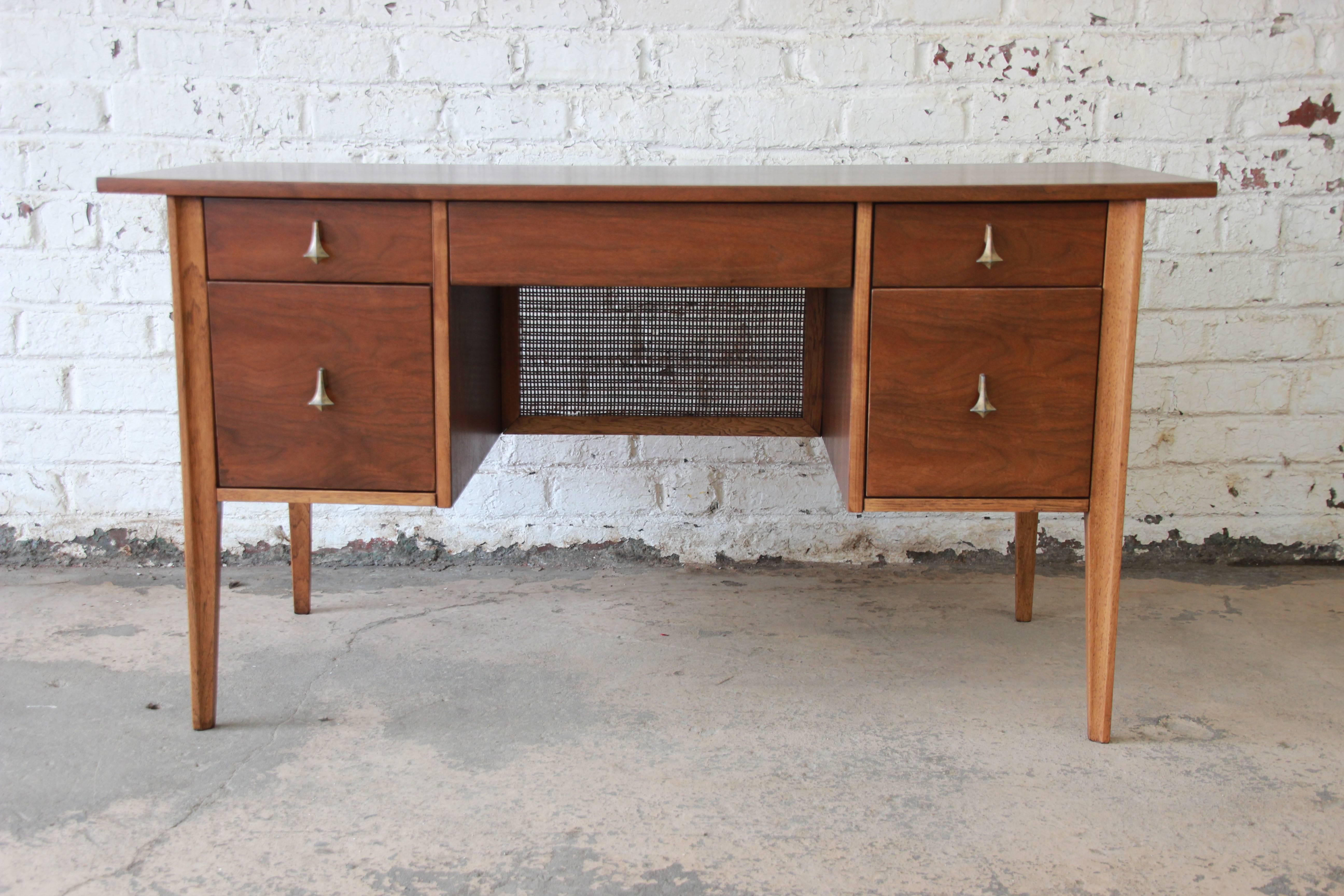 A rare and exceptional Broyhill Brasilia Mid-Century Modern sculpted walnut desk. The desk features gorgeous two-tone walnut wood grain and sleek midcentury design. It offers ample room for storage, with five dovetailed drawers. The desk is finished