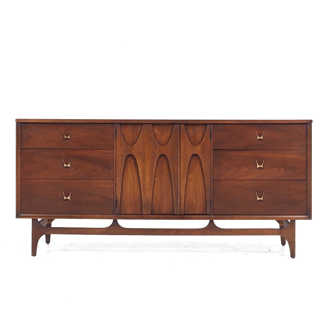 Broyhill Brasilia Mid Century Walnut 9 Drawer Lowboy Dresser

This lowboy measures: 66 wide x 19 deep x 31 inches high

All pieces of furniture can be had in what we call restored vintage condition. That means the piece is restored upon purchase so