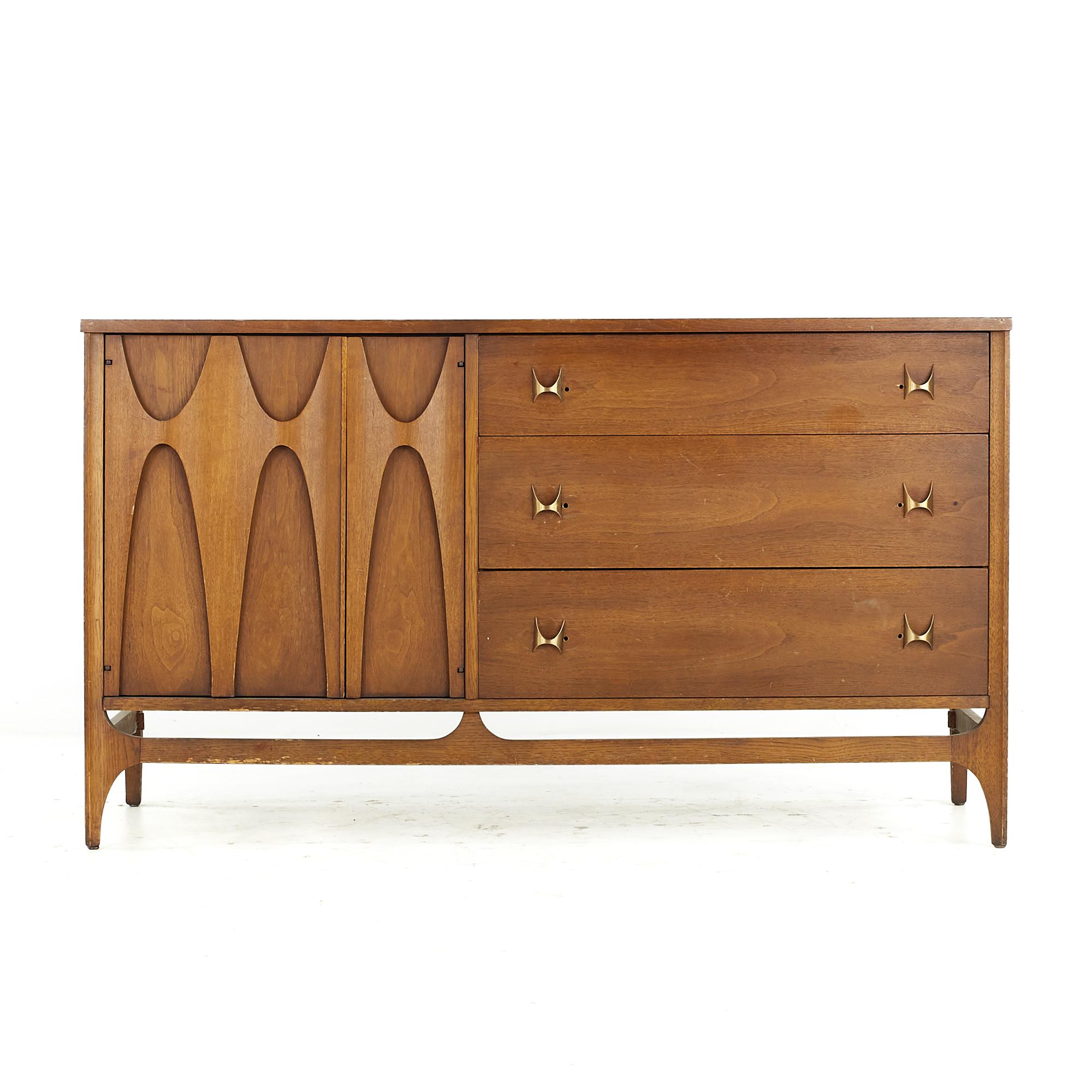 Broyhill Brasilia midcentury Walnut and Brass Offset Buffet

This buffet measures: 54 wide x 19 deep x 31 inches high

All pieces of furniture can be had in what we call restored vintage condition. That means the piece is restored upon purchase
