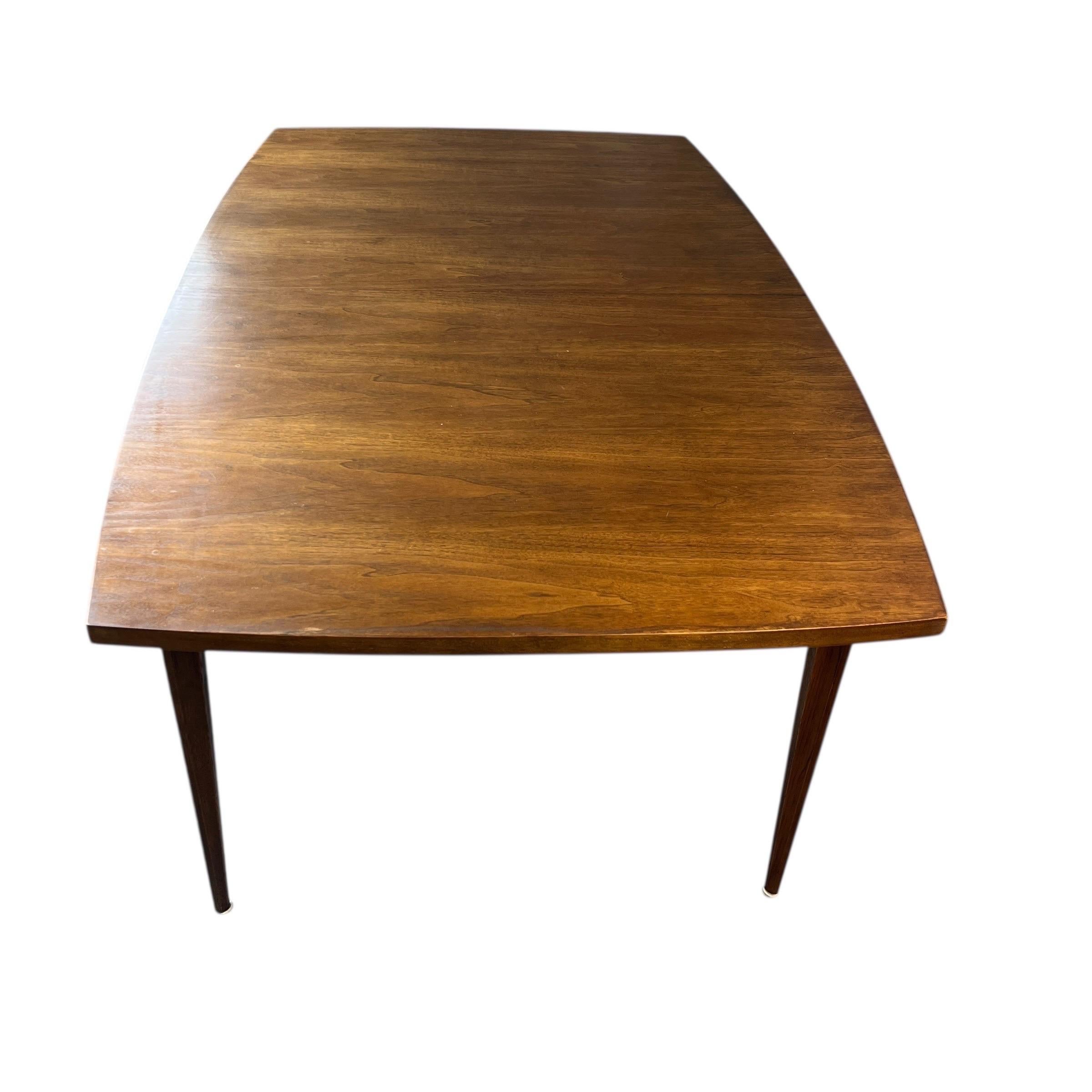 Nous proposons à la vente cette très belle table de salle à manger vintage Broyhill Brasilia en noyer du milieu du siècle avec une feuille.