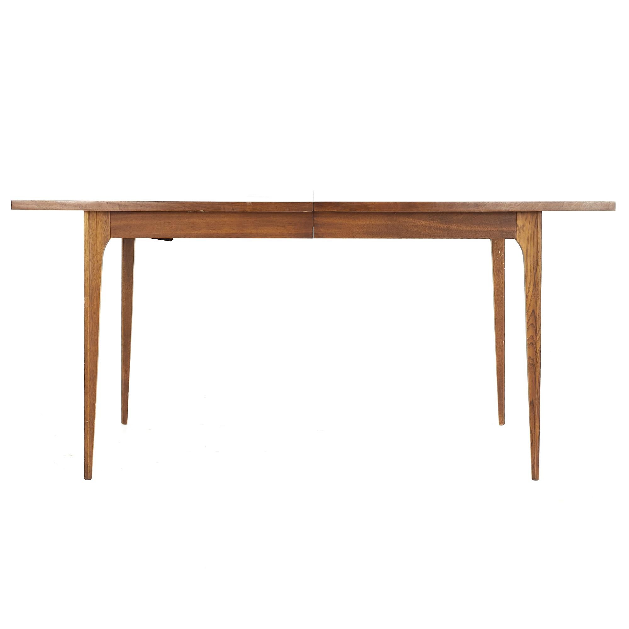 Broyhill Brasilia midcentury walnut dining table with 1 leaf.

This table measures: 66 wide x 40 deep x 29.75 high, the leaf measures 12 inches wide, making a maximum table width of 78 inches when the leaf is used.

All pieces of furniture can