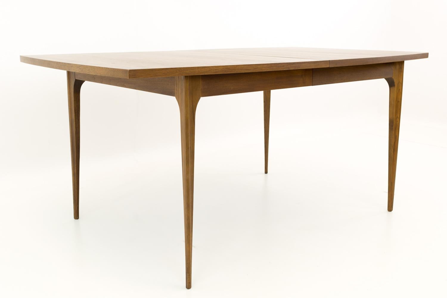 Broyhill Brasilia mid century walnut surfboard dining table - with one leaf.

Table measures: 66 wide x 40 deep x 30 inches high and has a chair clearance of 26 inches. When the 11