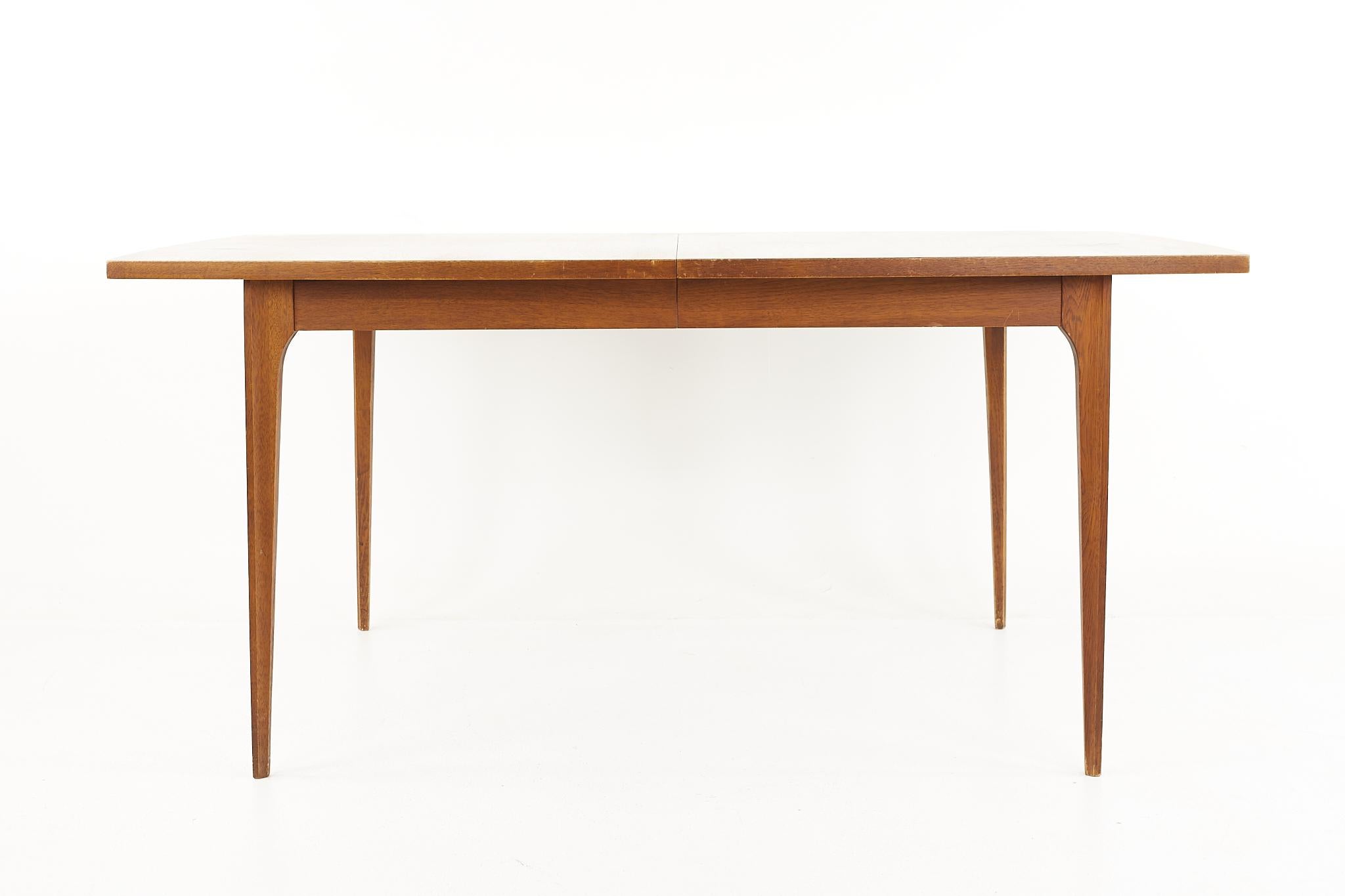 Broyhill Brasilia mid-century walnut surfboard dining table - with one leaf

Table measures: 66 wide x 40 deep x 30 inches high, with a chair clearance of 26 inches, the leaf is 12 wide making a maximum table width of 78 inches

All pieces of