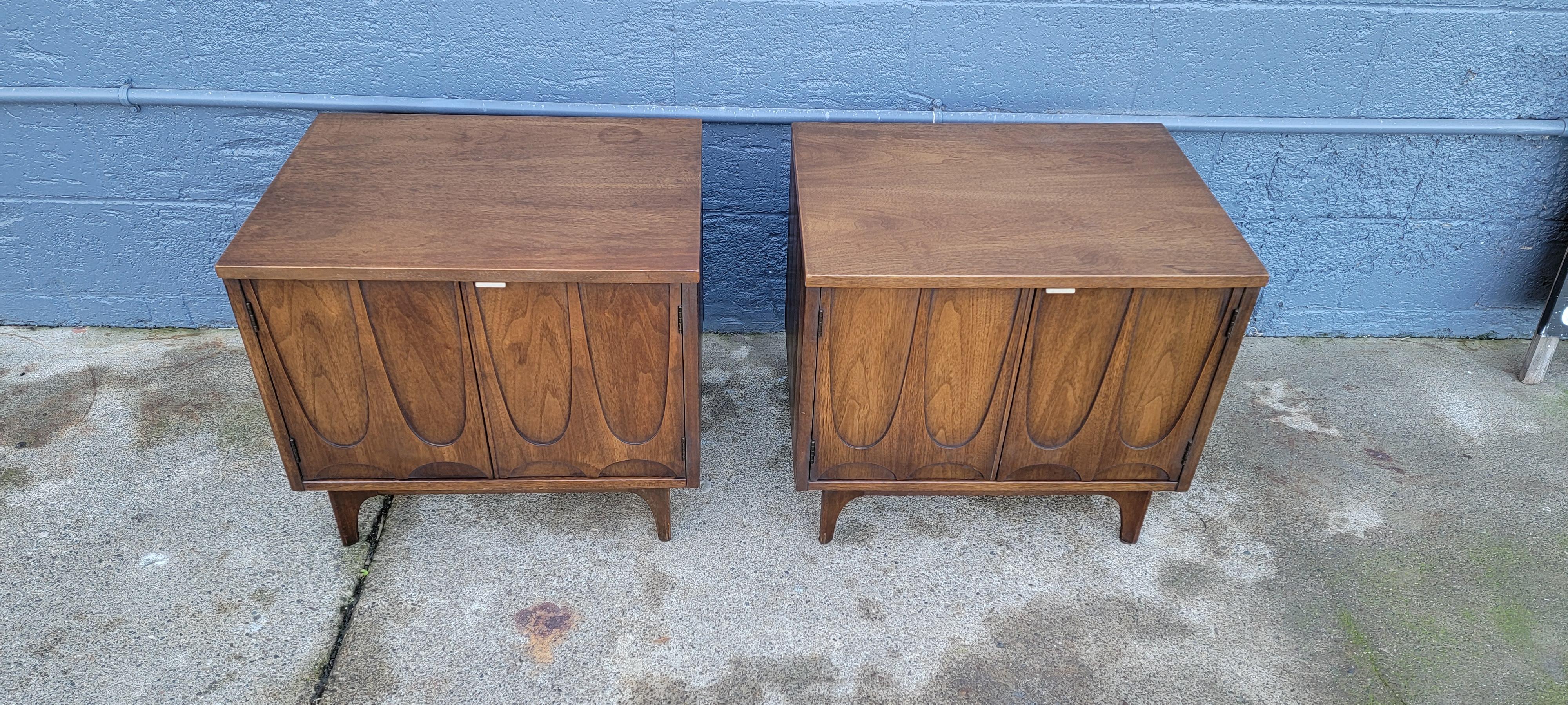 A pair of Mid-Century Modern Broyhill Brasilia nightstands / end tables. Introduced at the 1962 Seattle World’s Fair. Inspired by the newly created capital of Brazil designed by Oscar Niemeyer between 1956 and 1961. Features parabolic shape cabinets