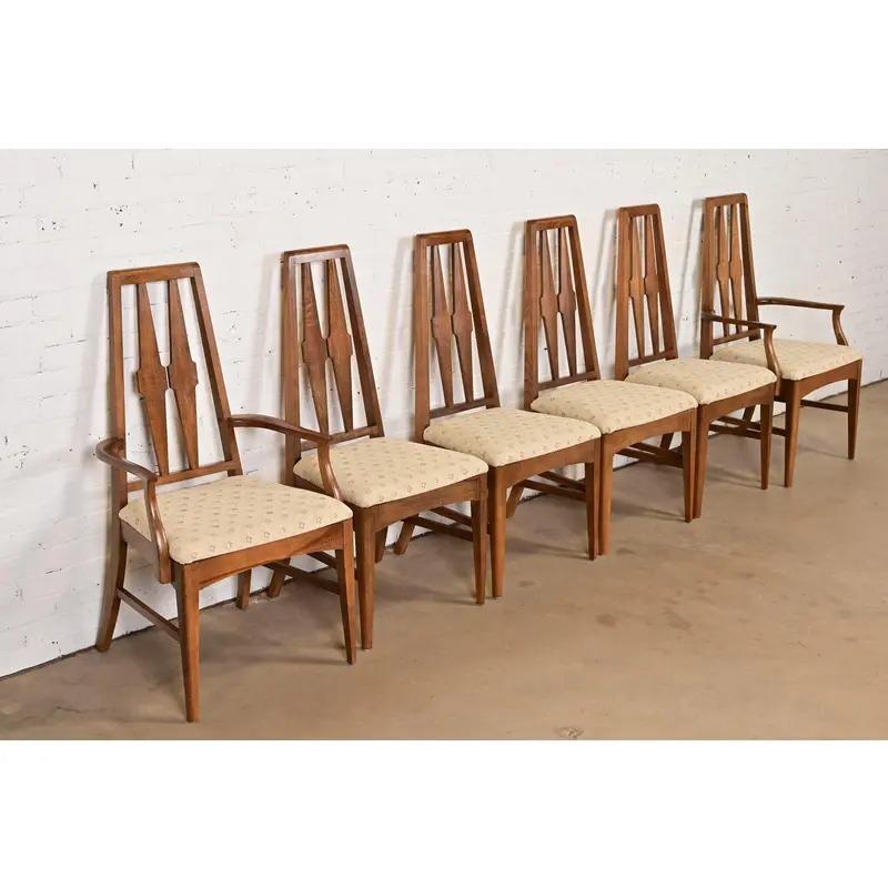 Uno splendido set di sei sedie da pranzo con schienale alto in stile Mid-Century Modern

Alla maniera di Broyhill Brasilia

USA, anni '60

Struttura in noce scolpita, con sedili imbottiti.

Misure:
Sedie laterali - 19,5