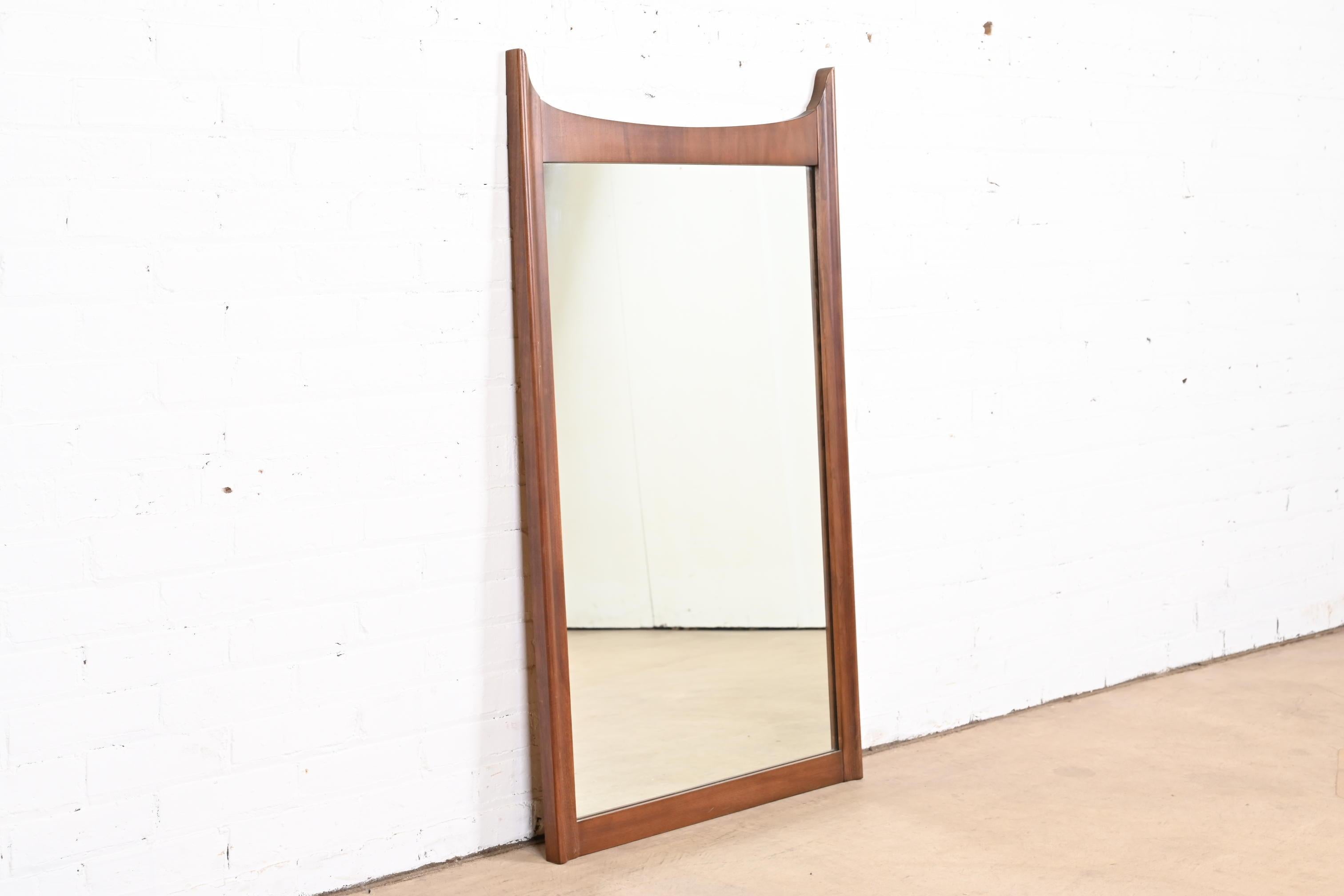 A stylish Mid-Century Modern sculpted walnut framed wall mirror

In the manner of Broyhill Brasilia

USA, 1960s

Measures: 27