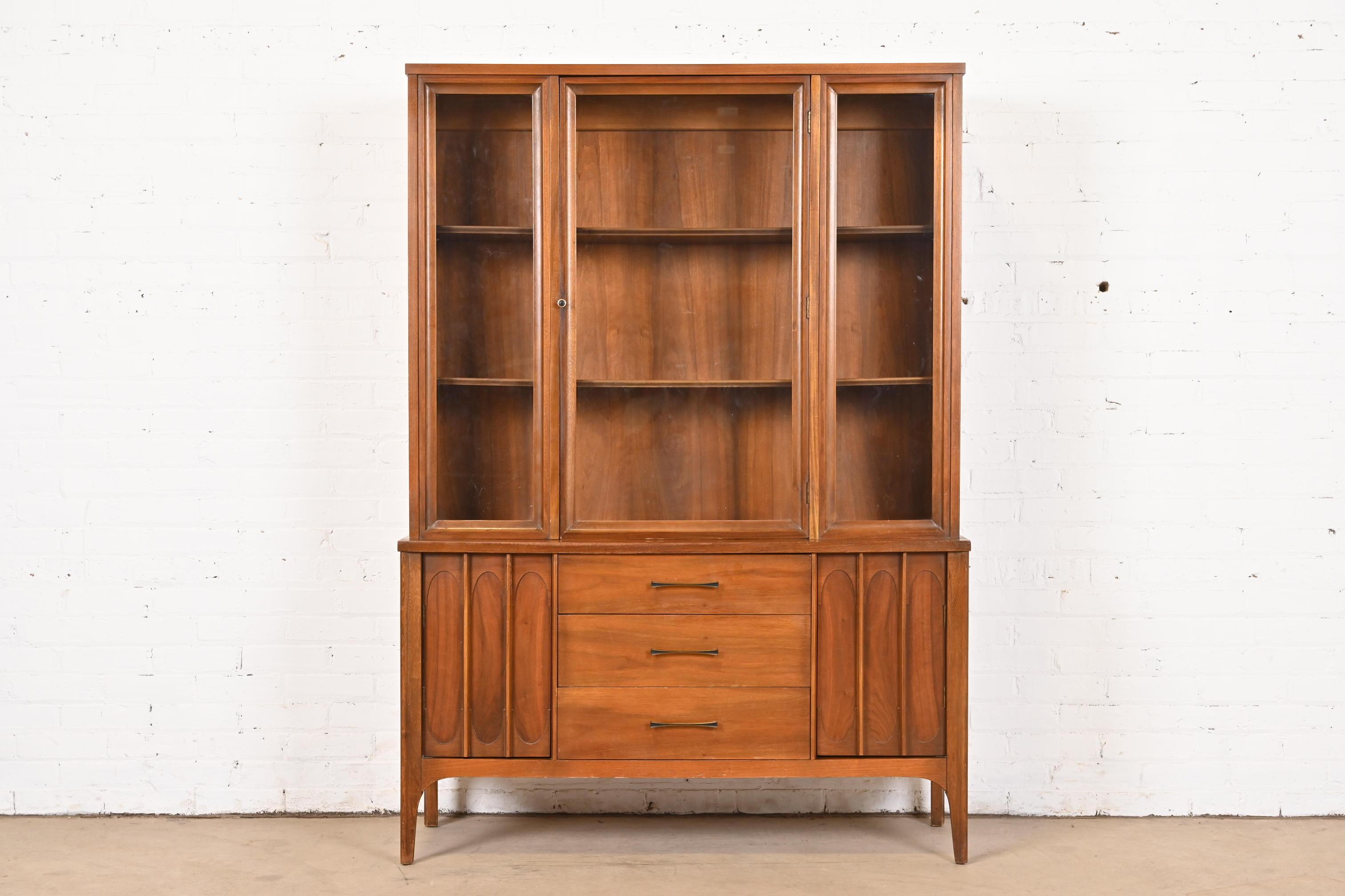 A beautiful Mid-Century Modern breakfront bookcase cabinet or dining cabinet

In the style of Broyhill Brasilia

USA, Circa 1960s

Sculpted walnut, with glass front doors and original hardware.

Measures: 47.25