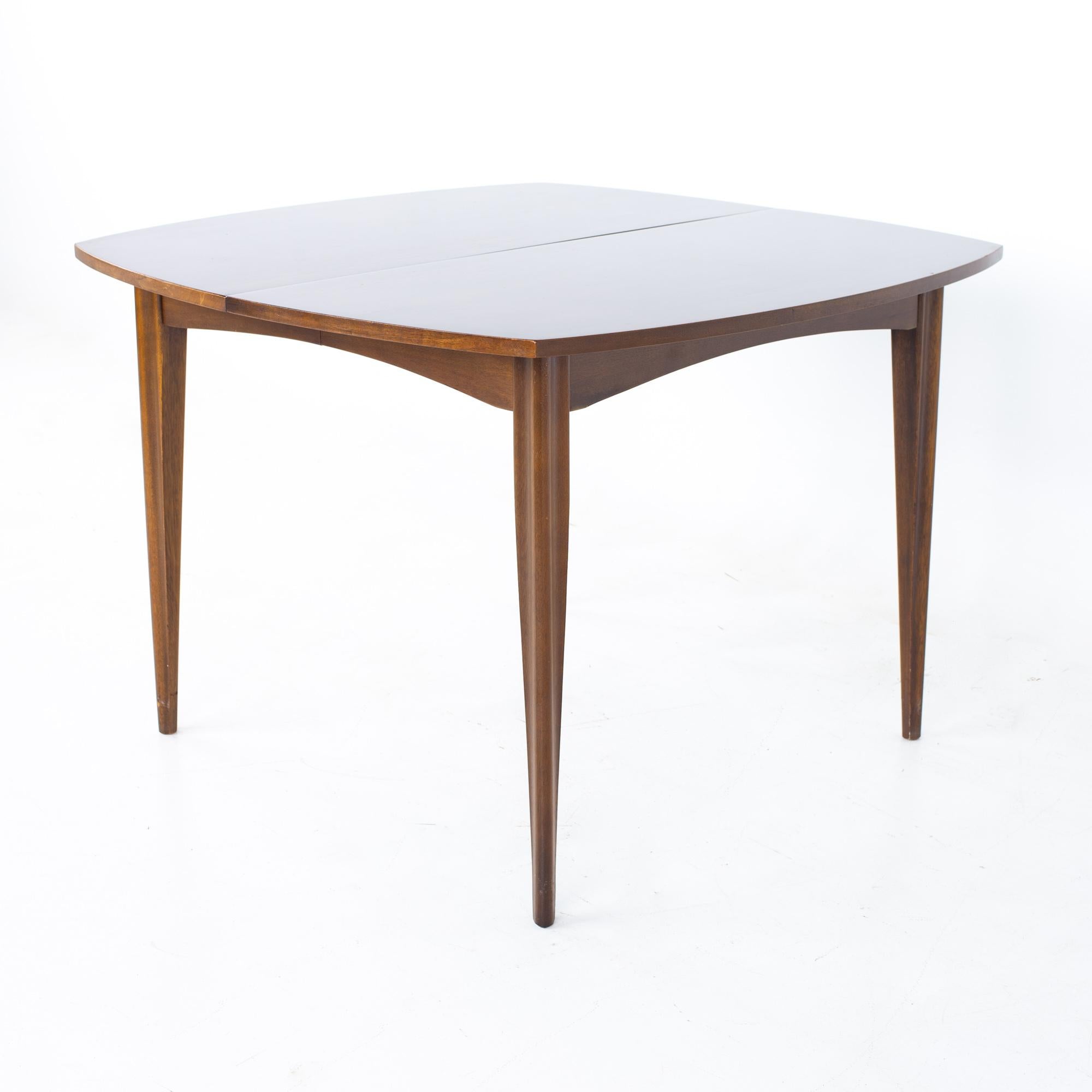 Broyhill emphasis mid century walnut surfboard expanding dining table
Table measures: 42 wide x 42 deep x 29.5 inches high; each leaf is 18 inches wide, making a maximum table width of 78 inches when both leaves are used, and a chair clearance of