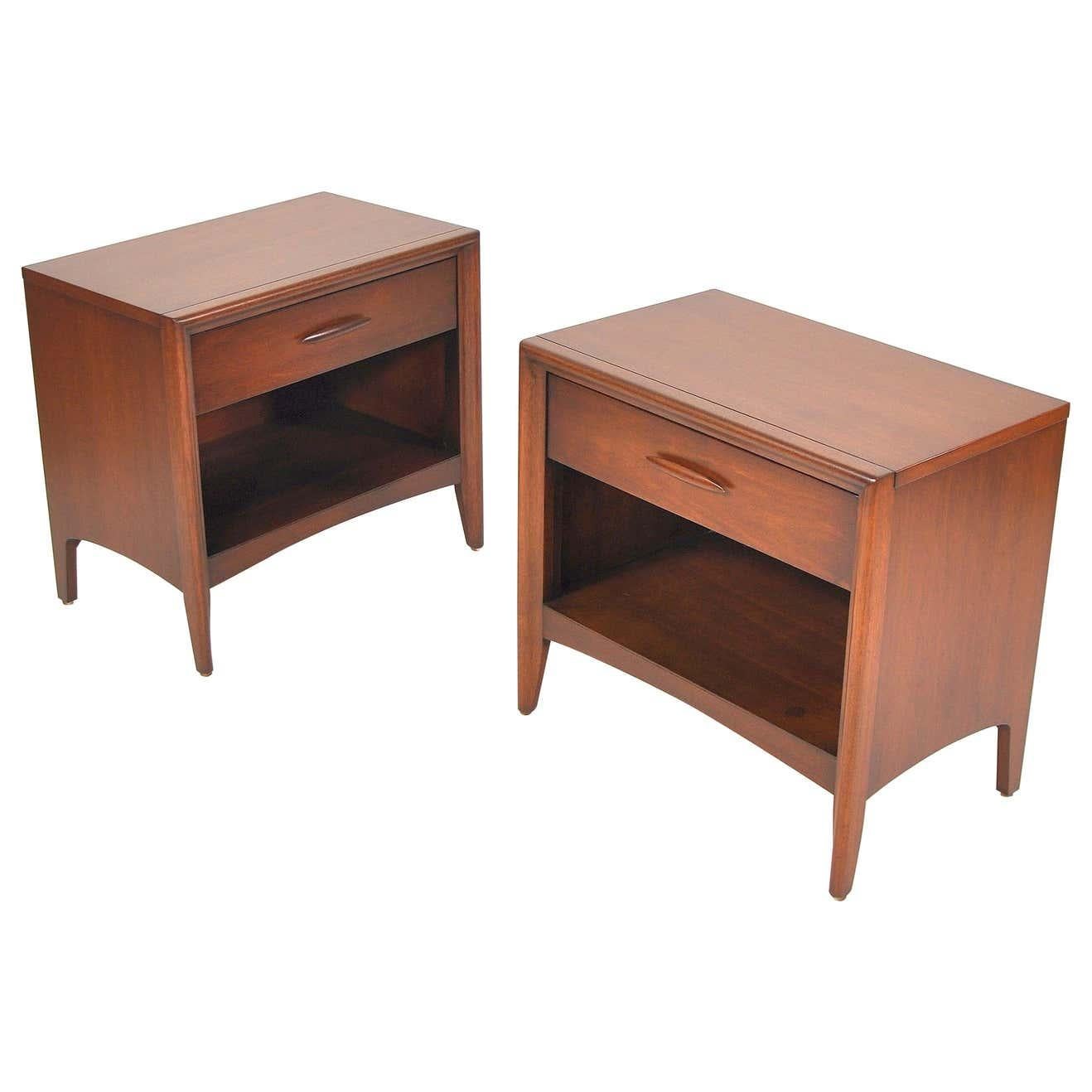 A vintage Mid-Century Modern walnut bedroom set from the Emphasis line manufactured by Broyhill in the 1960s comprising of a triple dresser and a pair of nightstands. The lowboy chest of drawers has nine drawers providing a ton of storage space.