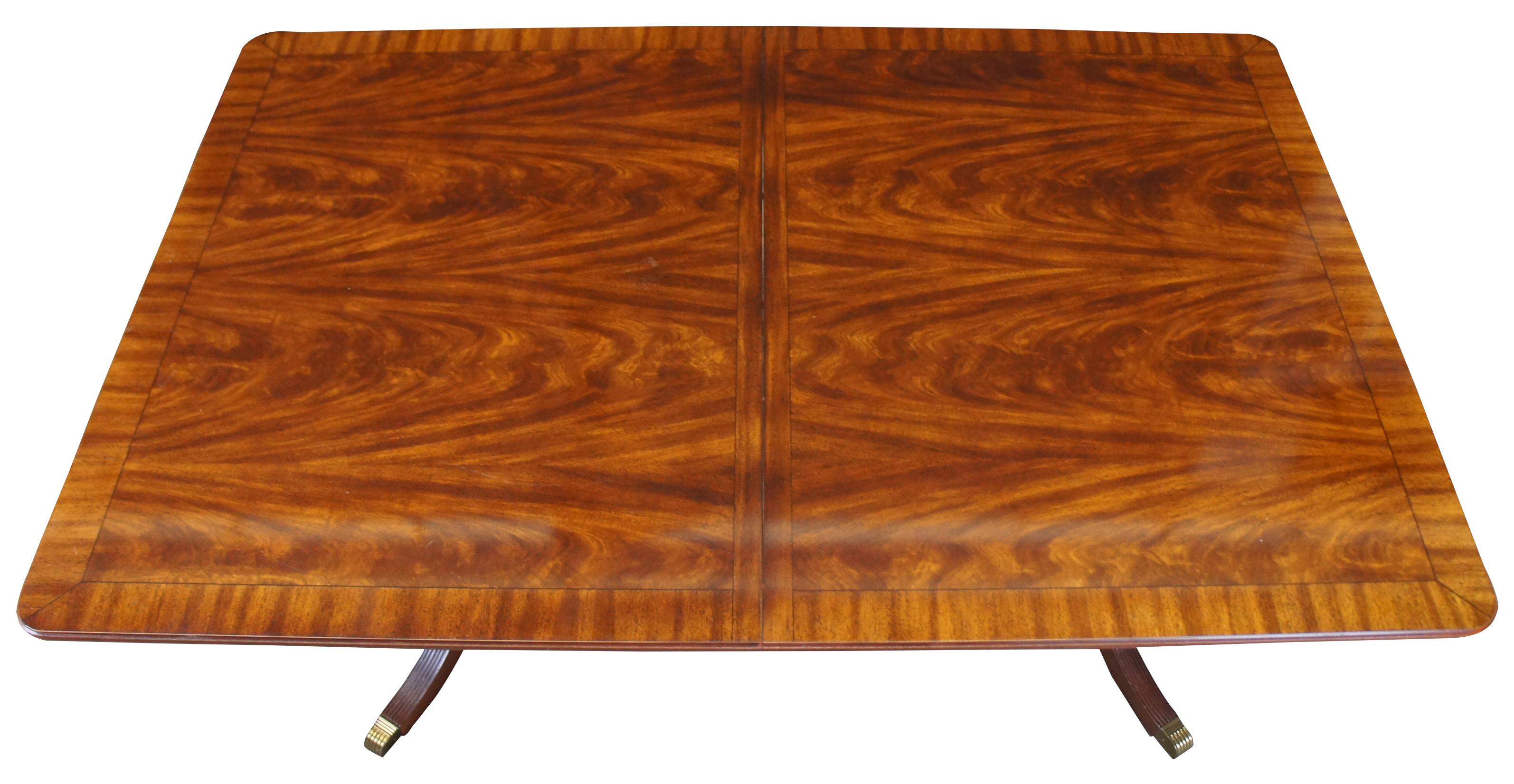 Broyhill Furniture traditional dining table, 512-5265-40. Features an extendable flame mahogany top. The table is supported by a double pedestal base with fluted legs and brass capped feet. 

Measures: Leaf width 18