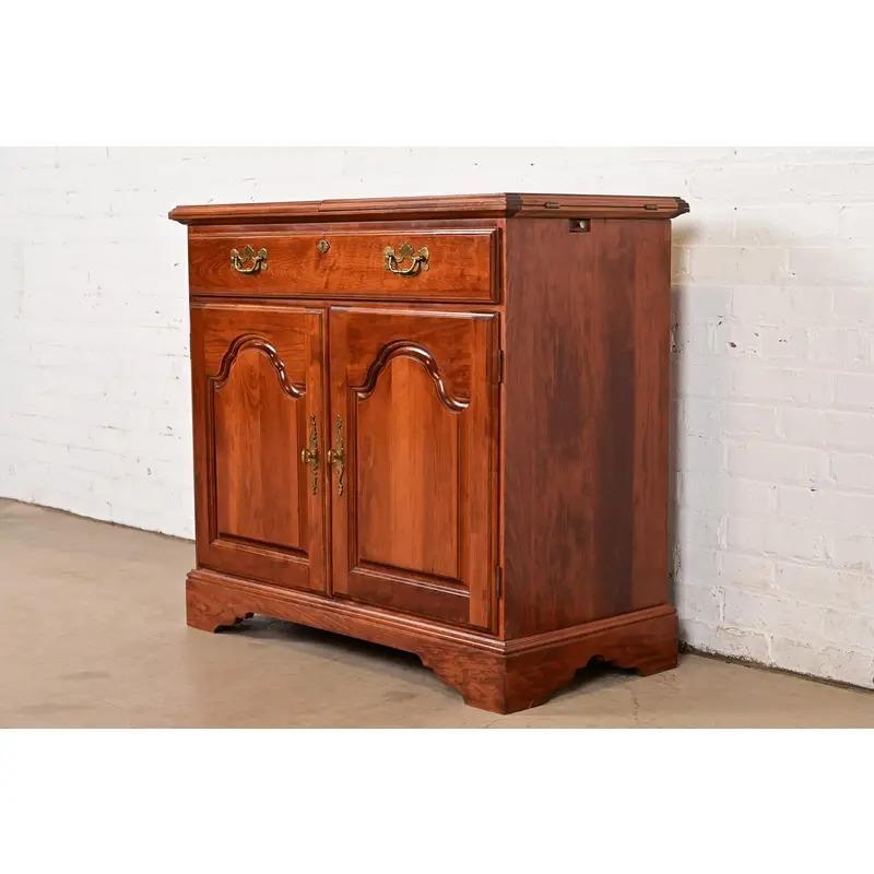 An exceptional Georgian or Chippendale style bar cabinet or buffet server

By Broyhill

USA, Late 20th Century

Carved cherry wood, with original brass hardware. Interior shelf is adjustable.

Measures: 36