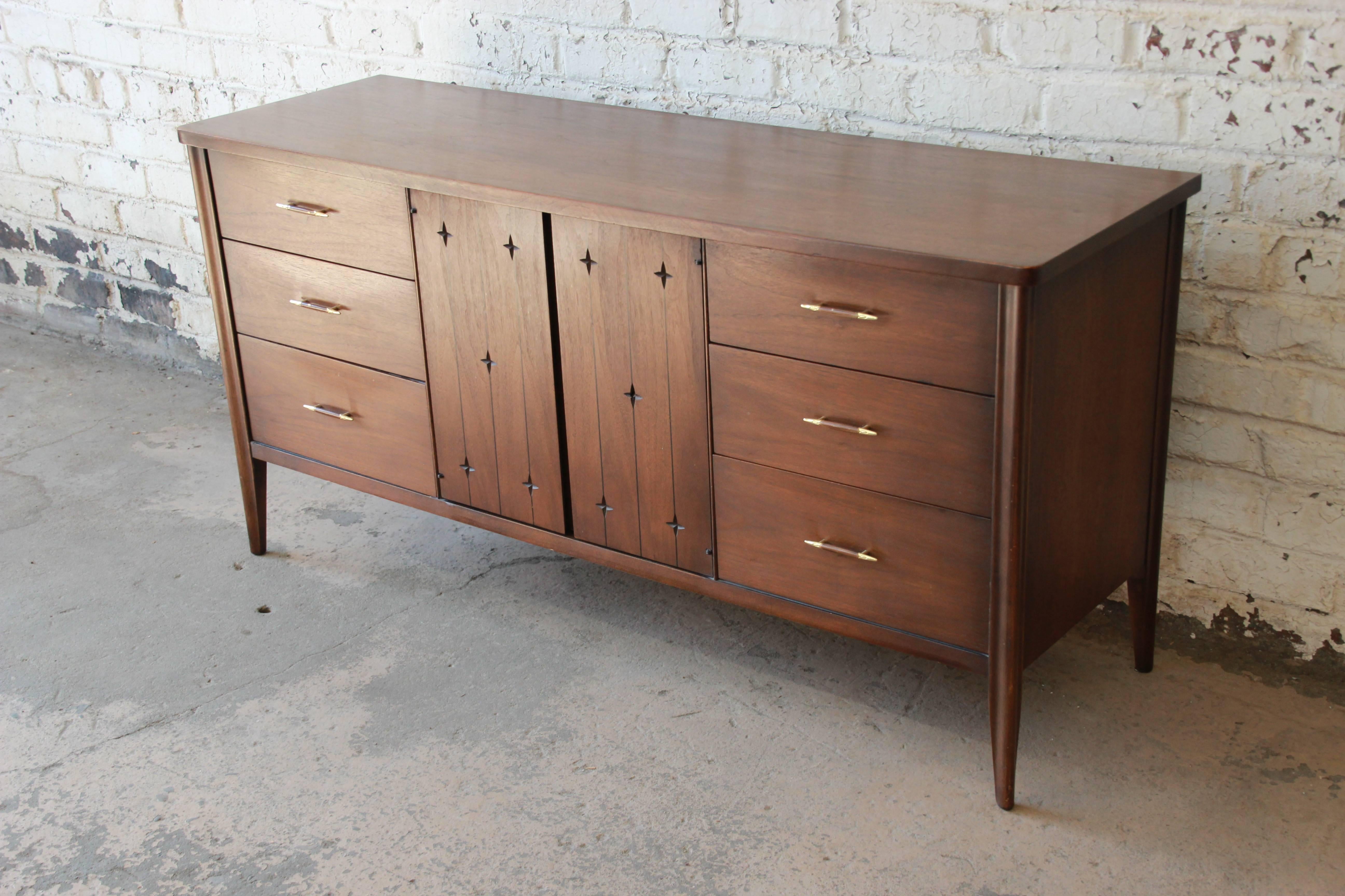 A very nice Mid-Century Modern sculpted walnut long triple dresser or credenza from the iconic 