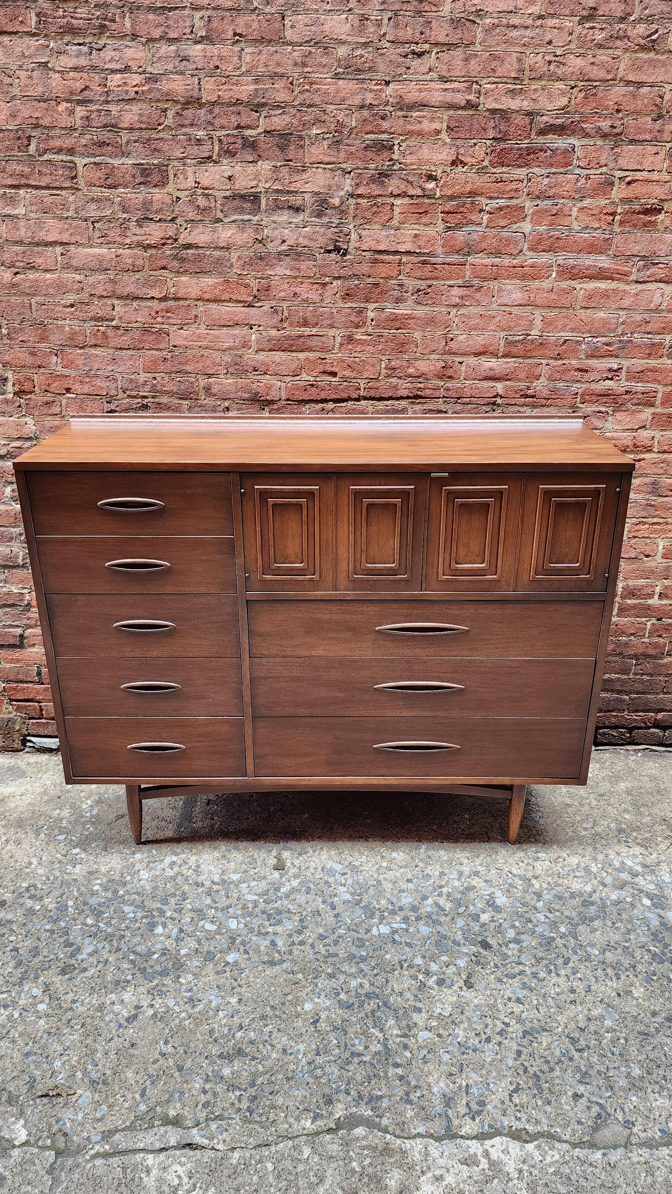 For your consideration we have this mid-century modern tall chest from the Broyhill Sculptra line of furniture. This Magna Chest is the largest tall chest made by Broyhill. It has an impressive amount of store with multiple drawers and a cubby area