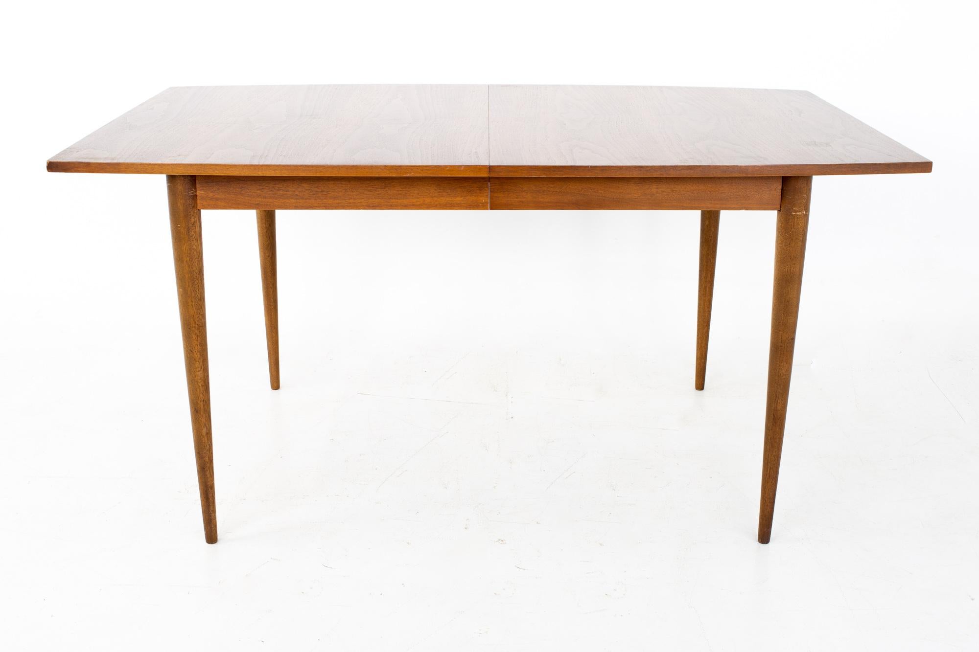 Broyhill Sculptra mid century walnut surfboard expanding dining table with 2 leaves

This table measures 60 wide x 40 deep x 29.5 inches high; with a chair clearance of 25.5. The leaves measure 12 inches wide, making a maximum table width of 84