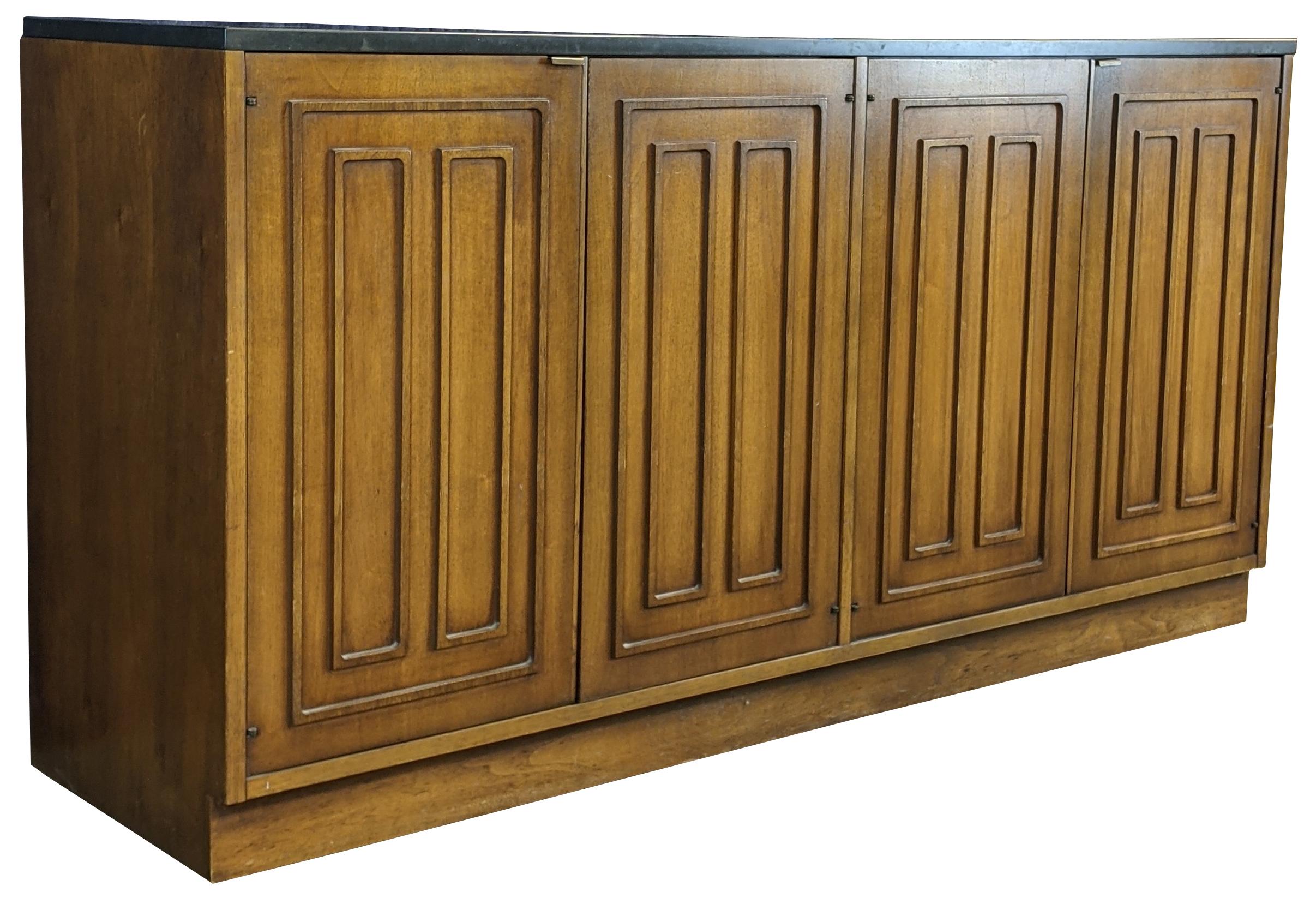 Broyhill Premier Sculptra collection buffet or credenza, circa 1960s. Made of walnut with slate top and Mid-Century Modern styling. The bottom doors open to reveal four drawers, three shelves, and a silverware / flatware drawer.
              