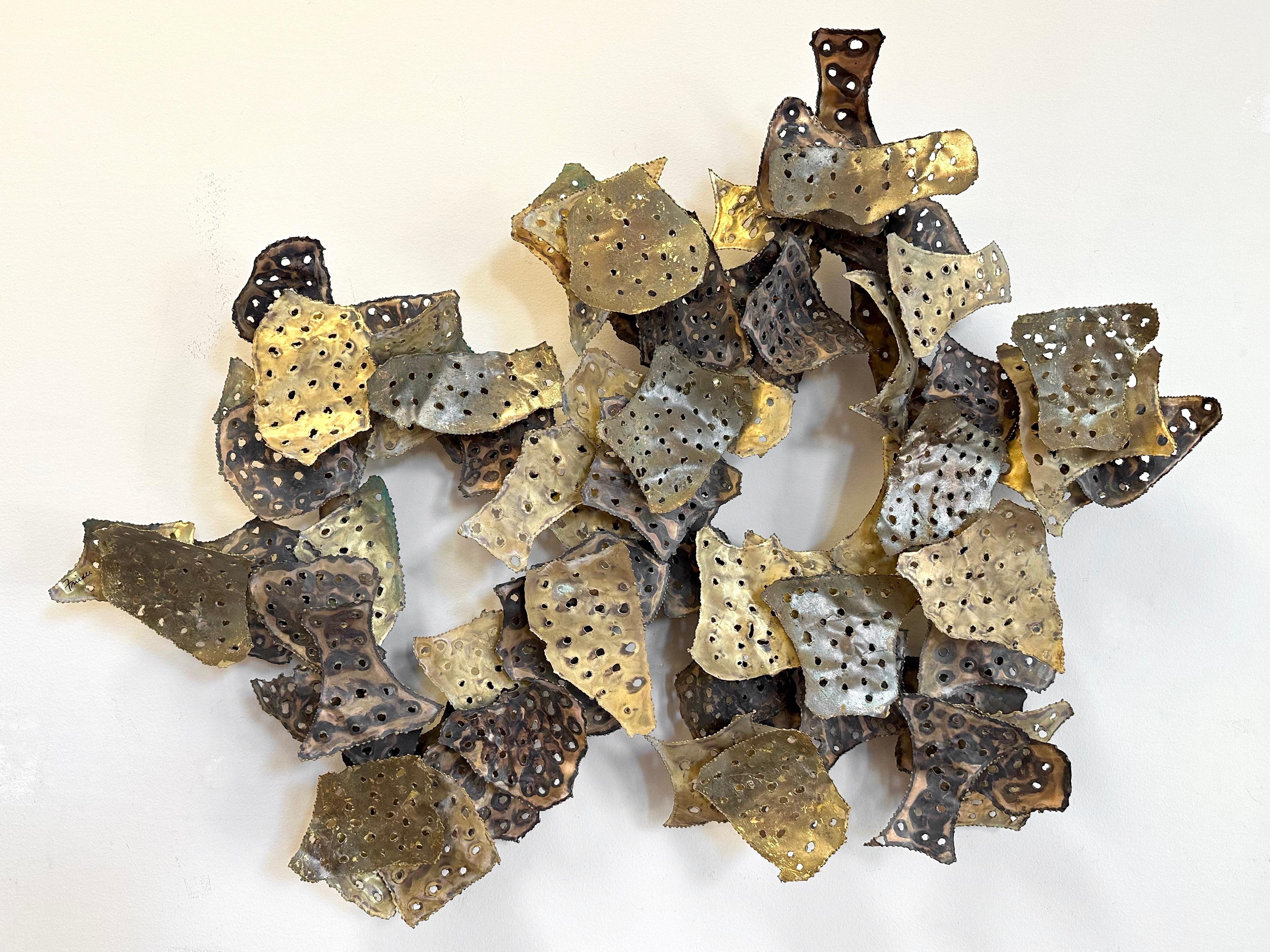 A large 1970s Brutalist metal wall sculpture by Bruce and William Friedle, signed.

Abstract, torch cut, perforated brass and copper leaf-like sheet metal elements with varying patinas and blackened details are loosely arranged in overlapping