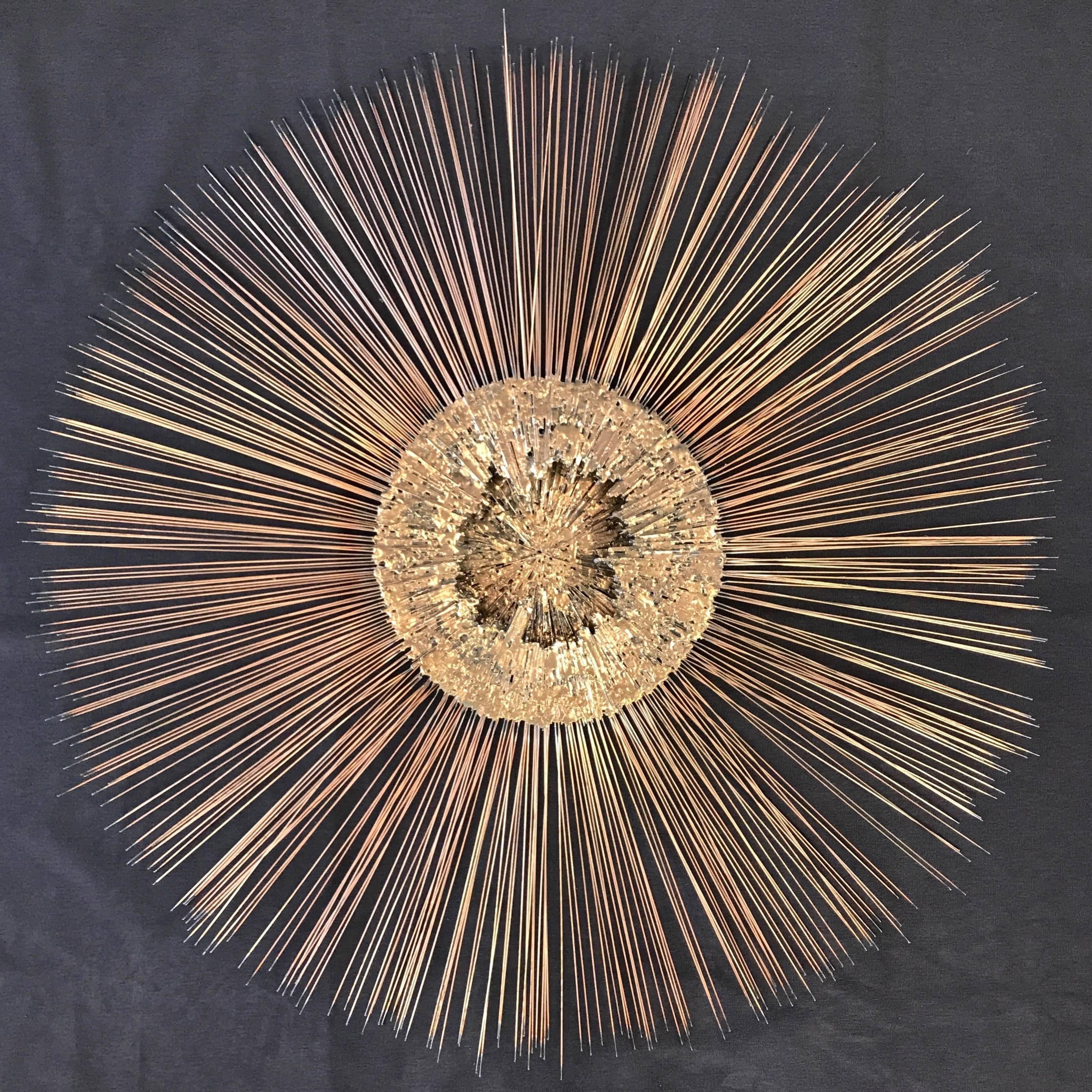A majestically-sized sunburst or starburst mixed-metal Brutalist wall sculpture by Bruce and William Friedle.

Hundreds of long, thin copper rods with blackened tips resembling burnt matchsticks radiate from a multi-depth, highly textural, molten